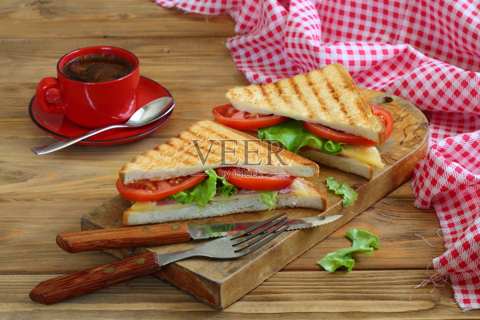 用西红柿、奶酪和火腿做的三明治，在深色的木制背景上照片摄影图片