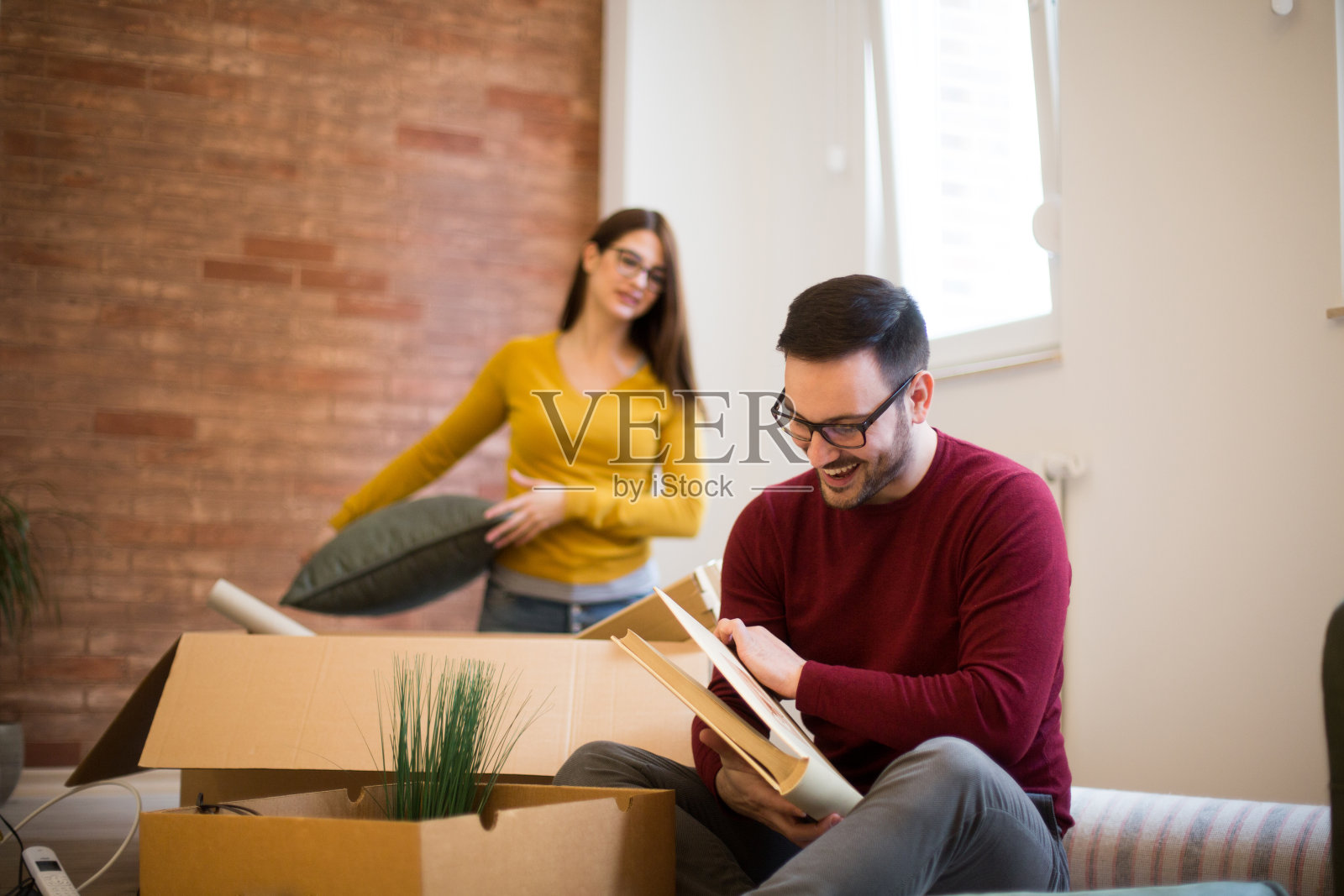 一对顽皮的年轻夫妇在他们的新公寓里照片摄影图片