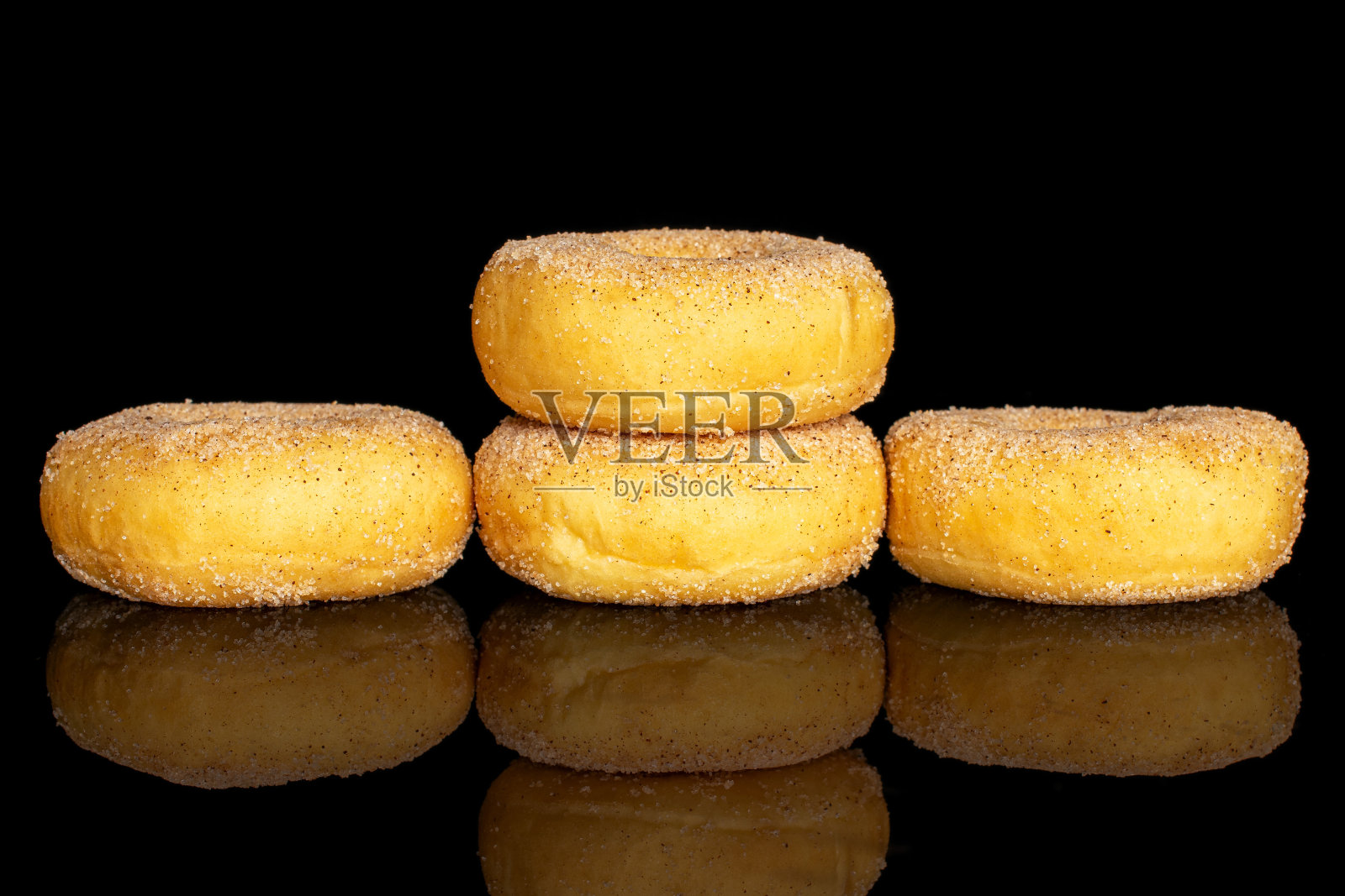 迷你肉桂甜甜圈孤立在黑色玻璃上照片摄影图片