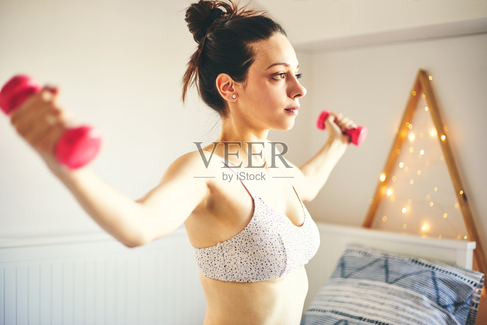 迷人的健康女人在家里锻炼。照片摄影图片