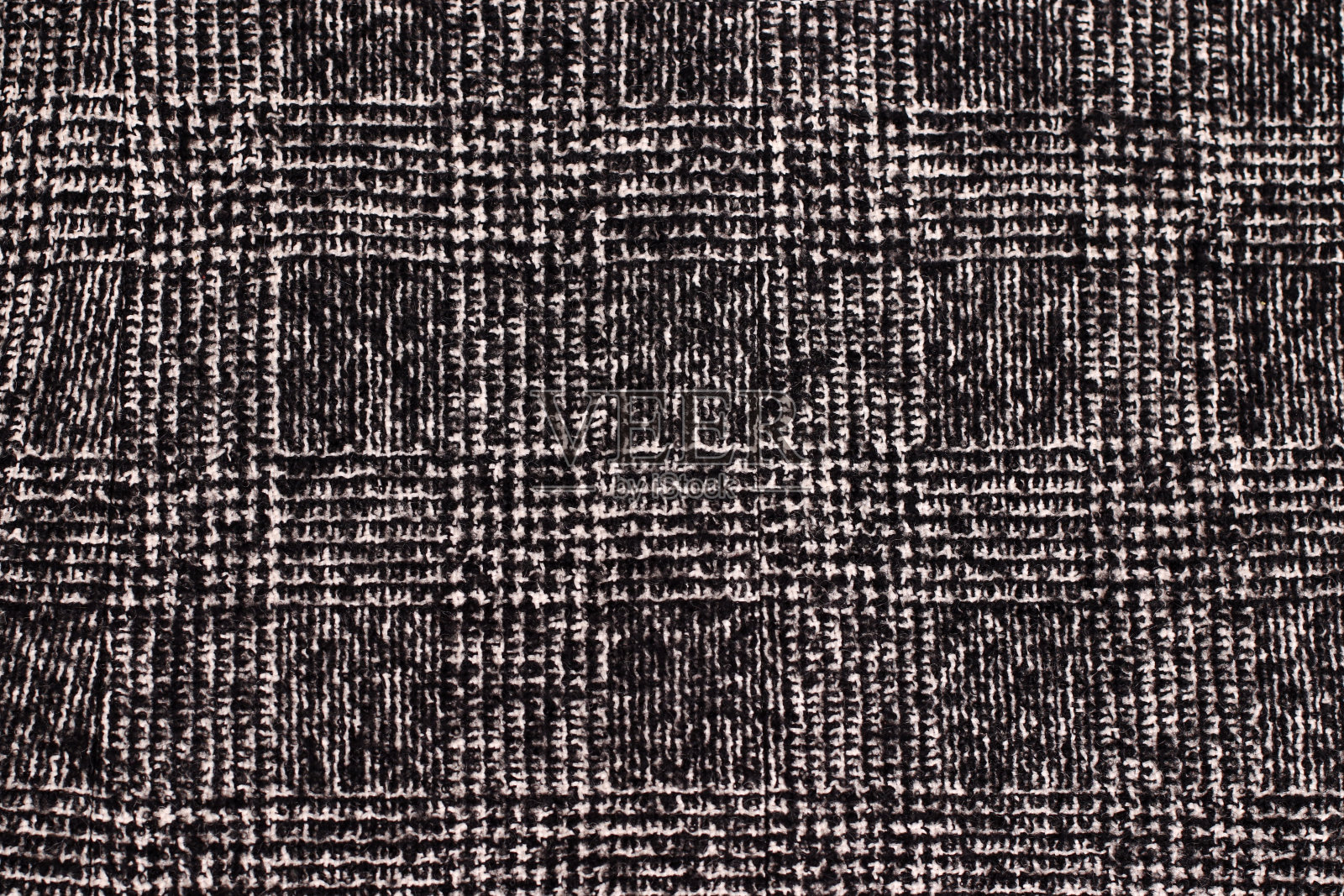 黑白笼纹织物。羊毛背景纹理。外套特写。昂贵的女人的外套。纺织暖深色针织布背景。照片摄影图片