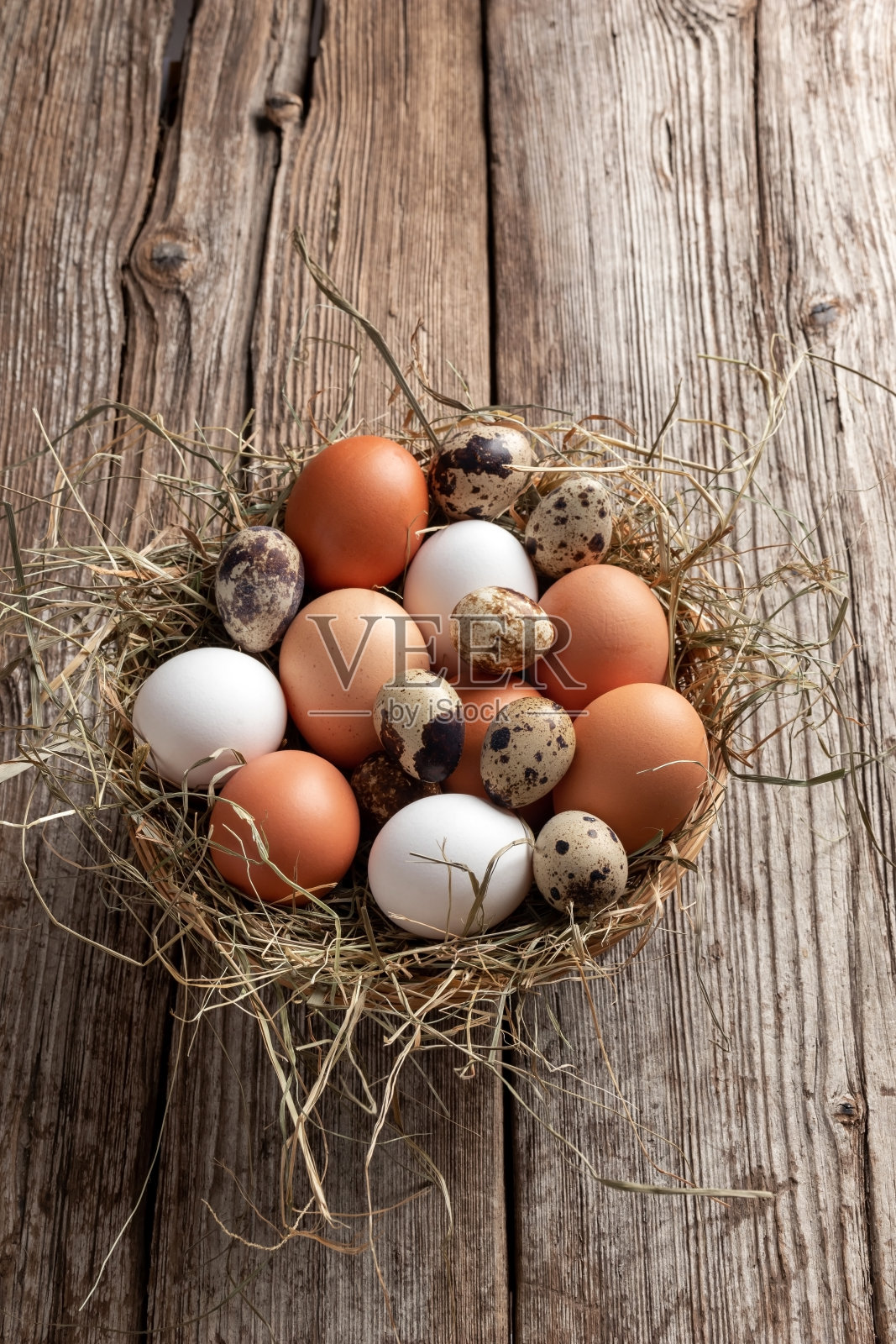 母鸡和鹌鹑的蛋放在柳条篮子里照片摄影图片