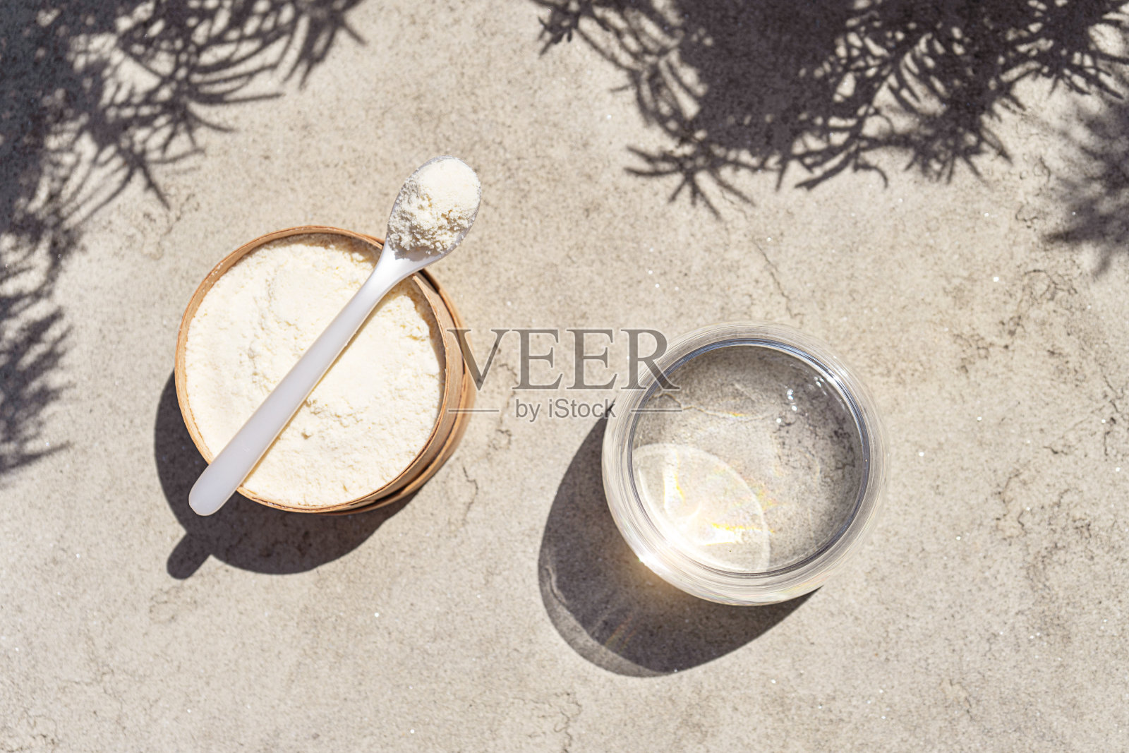 特写胶原蛋白与勺子和一杯水在混凝土背景照片摄影图片