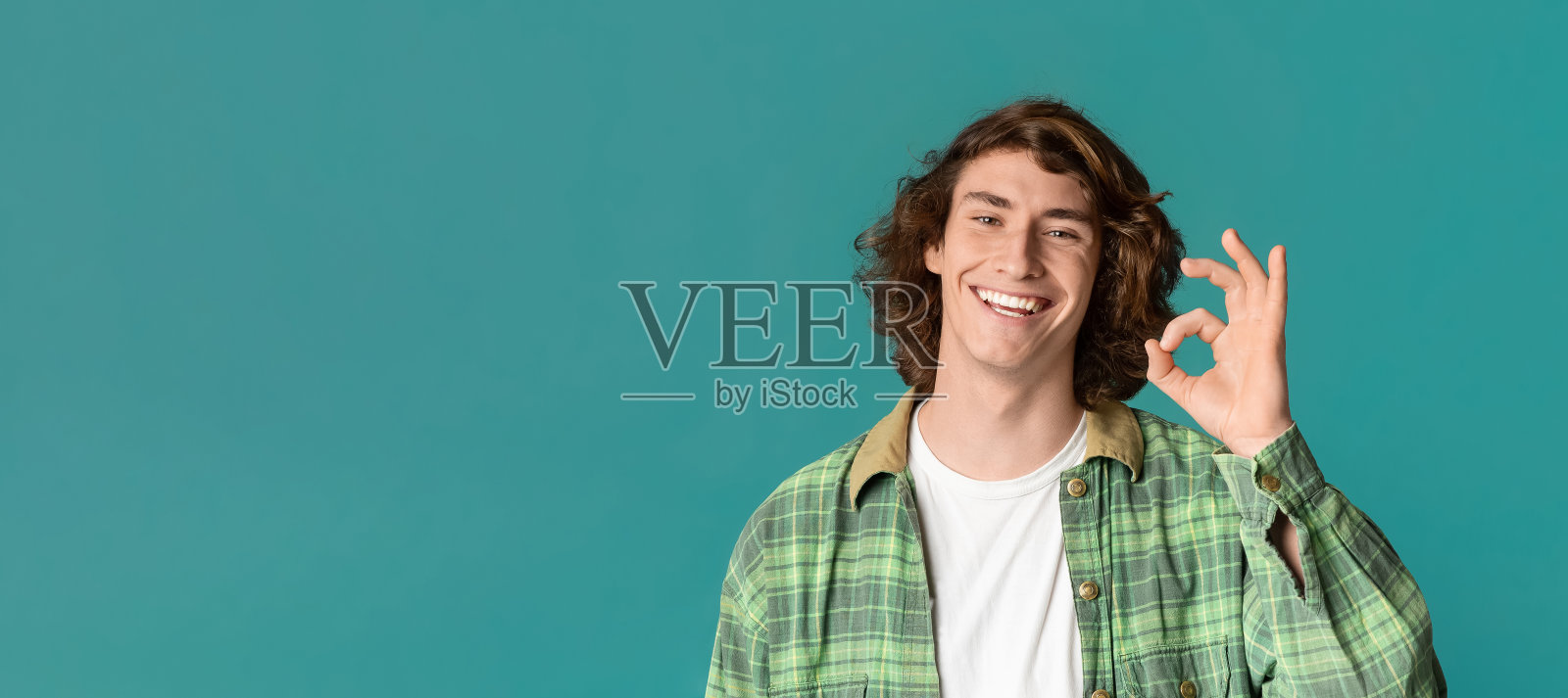 在彩色背景上做出OK手势的迷人少女，复制空间。全景图照片摄影图片