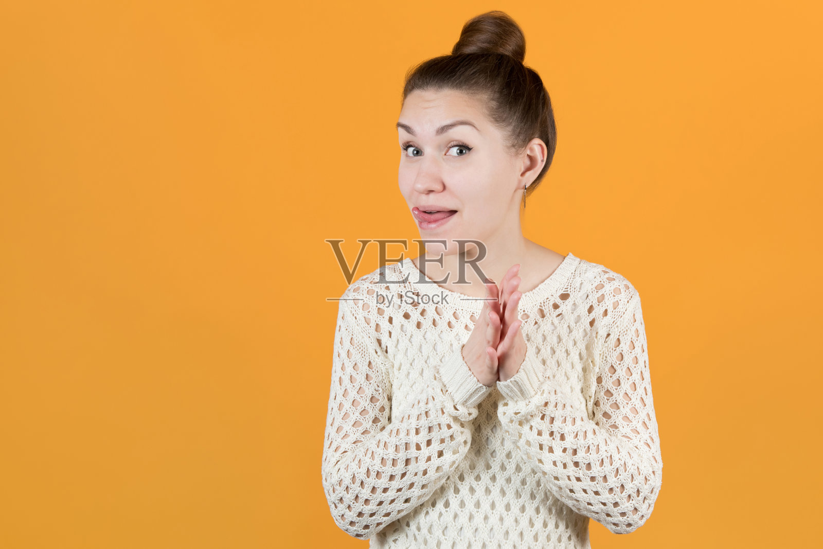 少女狡黠一笑，搓手吐舌照片摄影图片