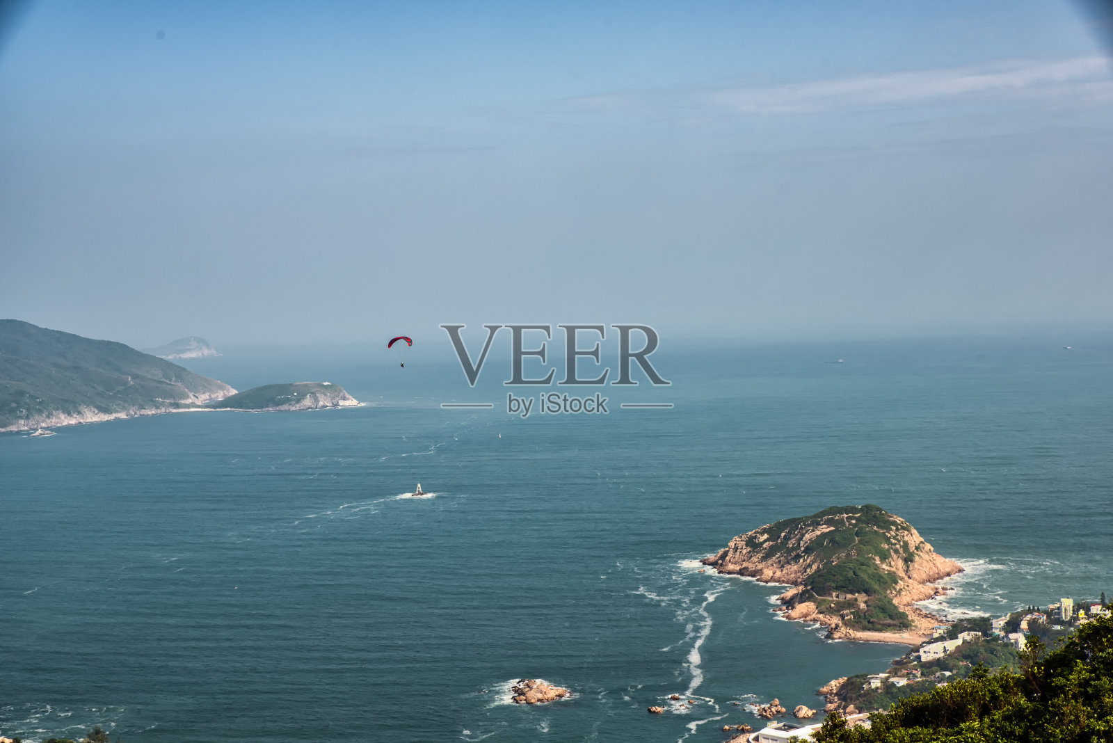 香港石澳郊野公园内，一架滑翔伞从石澳的龙背径上滑翔而过照片摄影图片