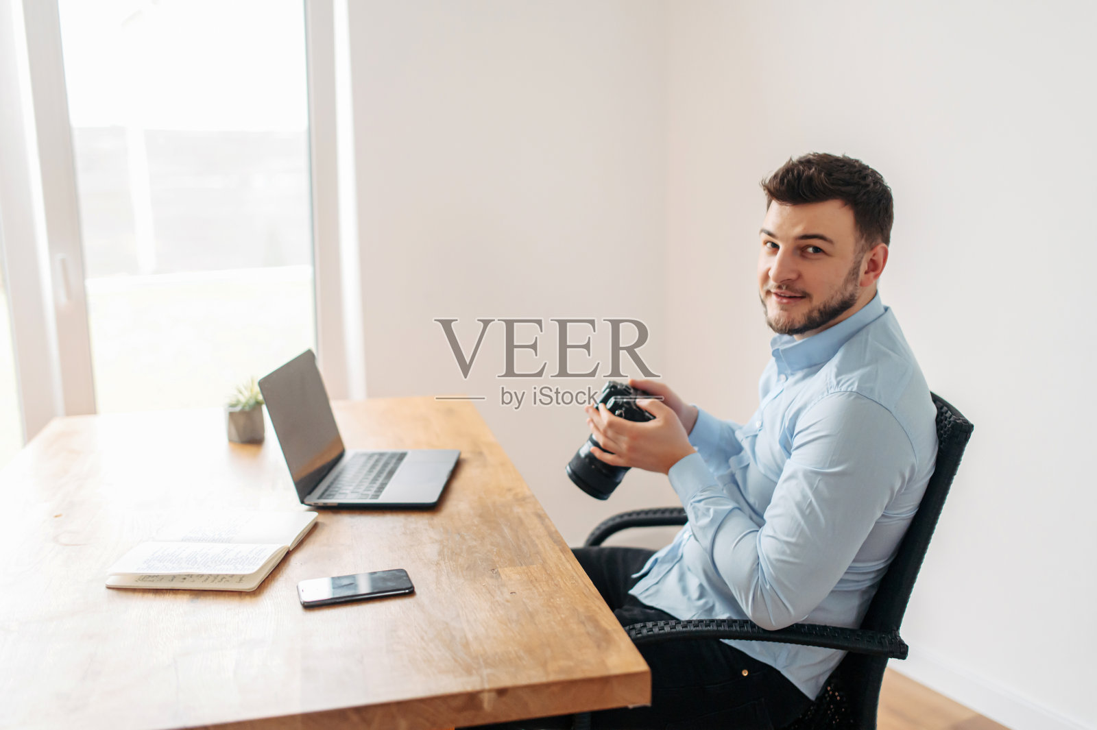 办公室里穿着蓝色衬衫的年轻人照片摄影图片