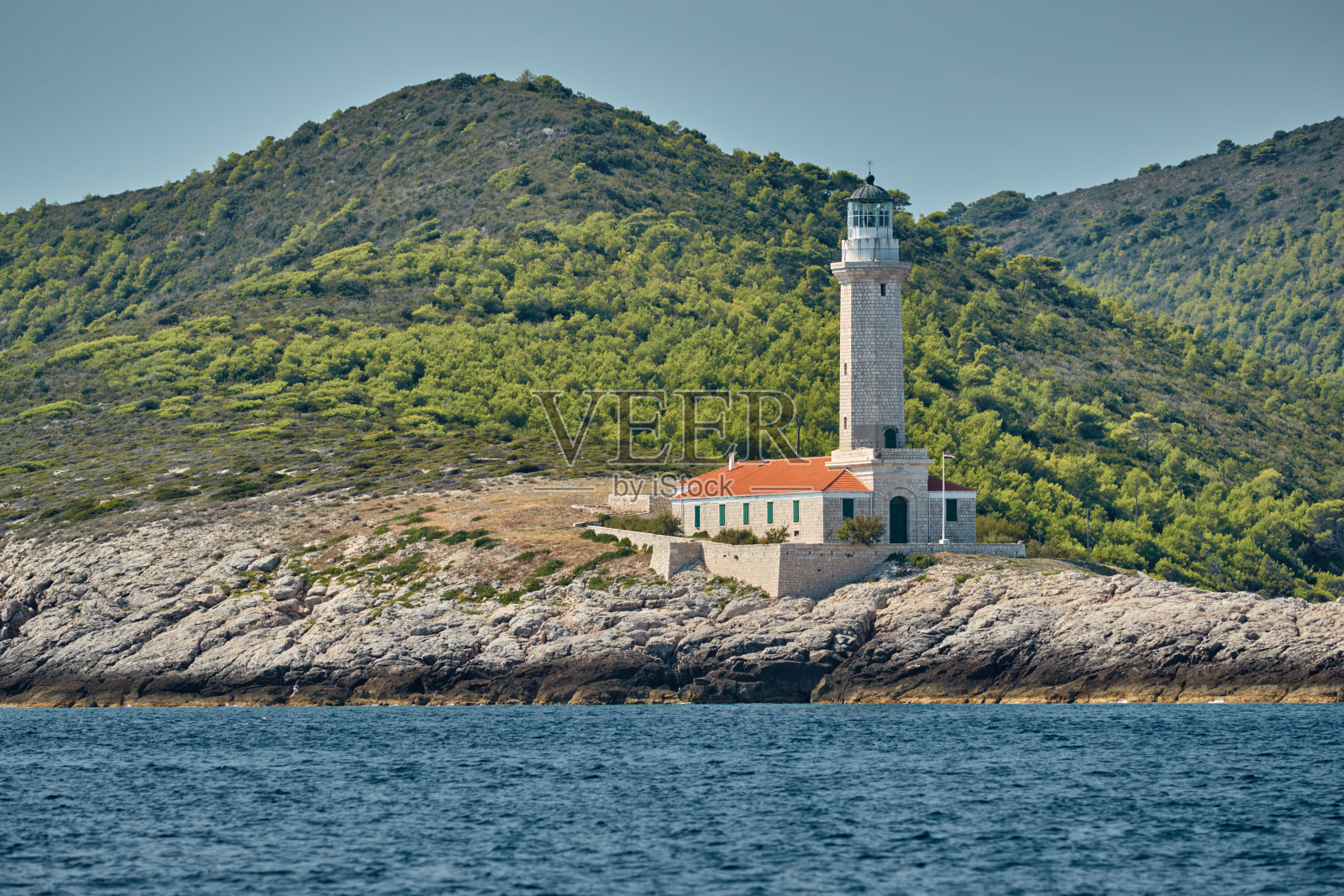 在克罗地亚岛附近的灯塔维斯在日落，一个岩石海岸，梯子到一个灯塔，一个小海角照片摄影图片
