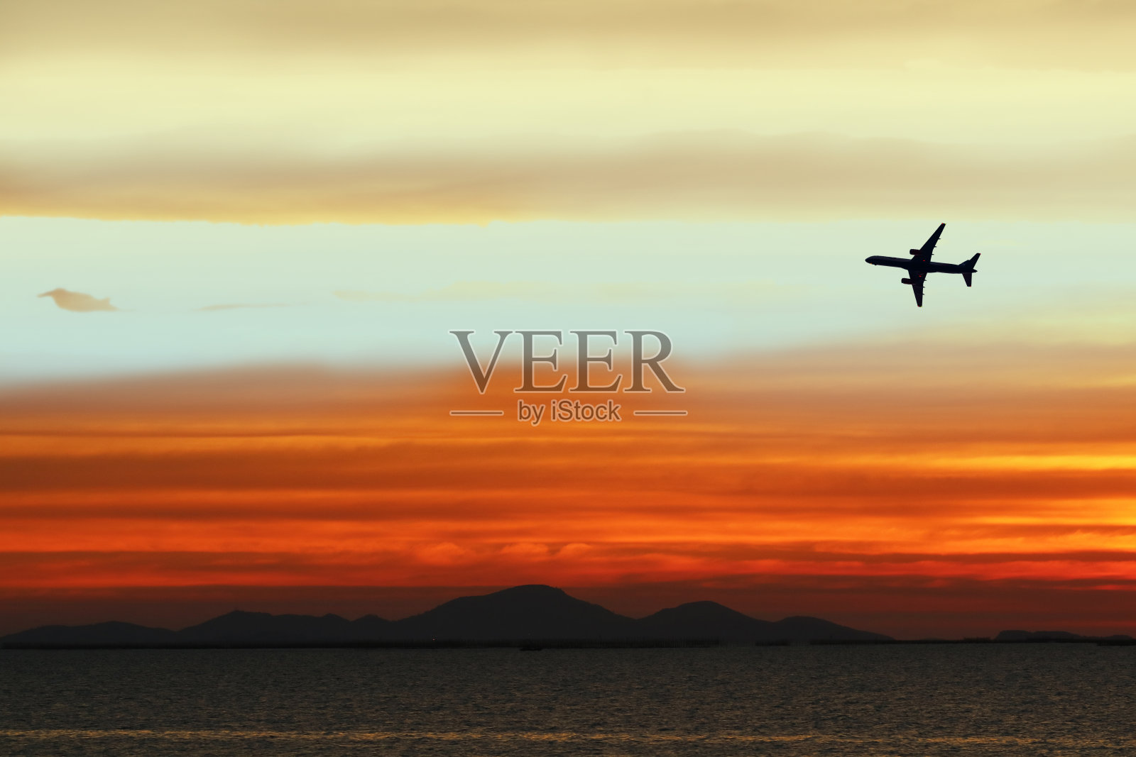 剪影飞机上的天空在日落背面的云白橙色黄红色照片摄影图片