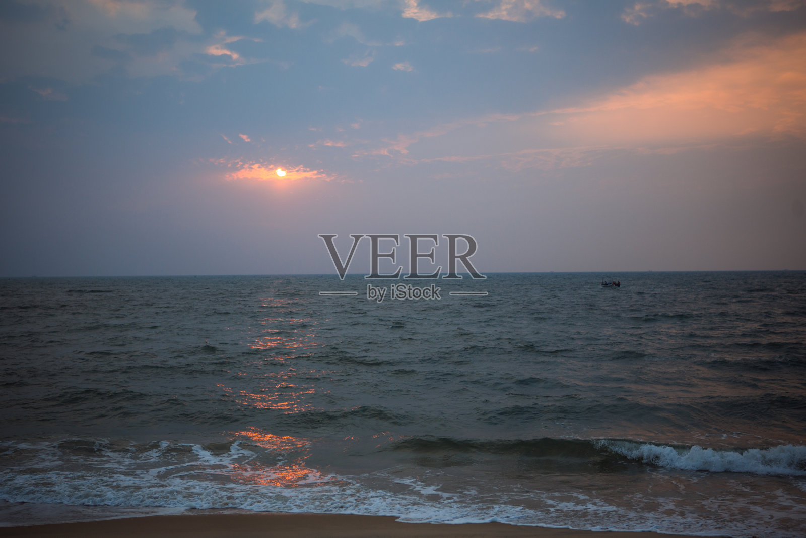 橙色日落在印度的海上-橙色和粉红色的天空，深蓝色的海。照片摄影图片