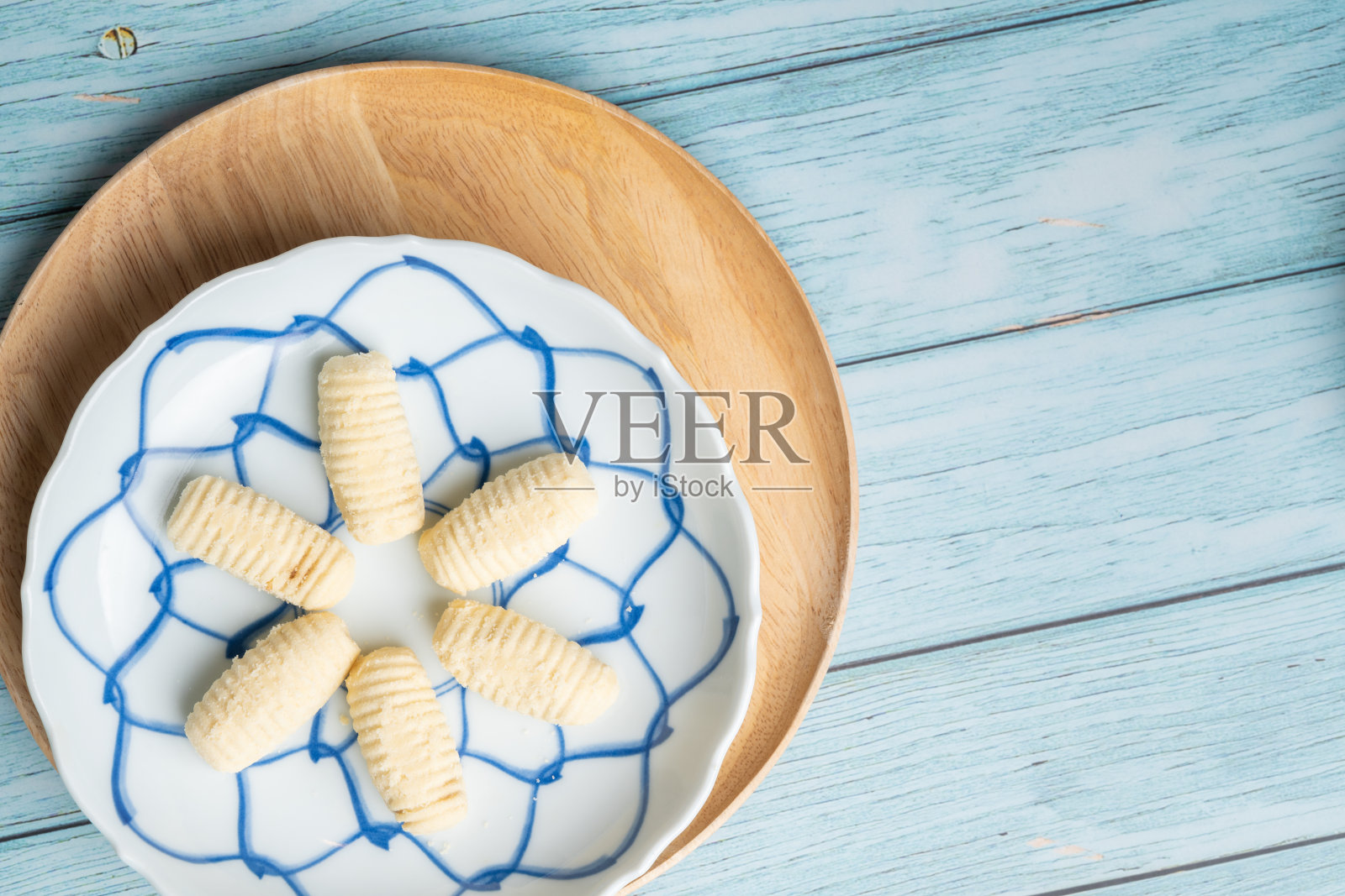 泰国传统饼干在蓝色的盘子和木制圆板与蓝色的乡村老木桌照片摄影图片