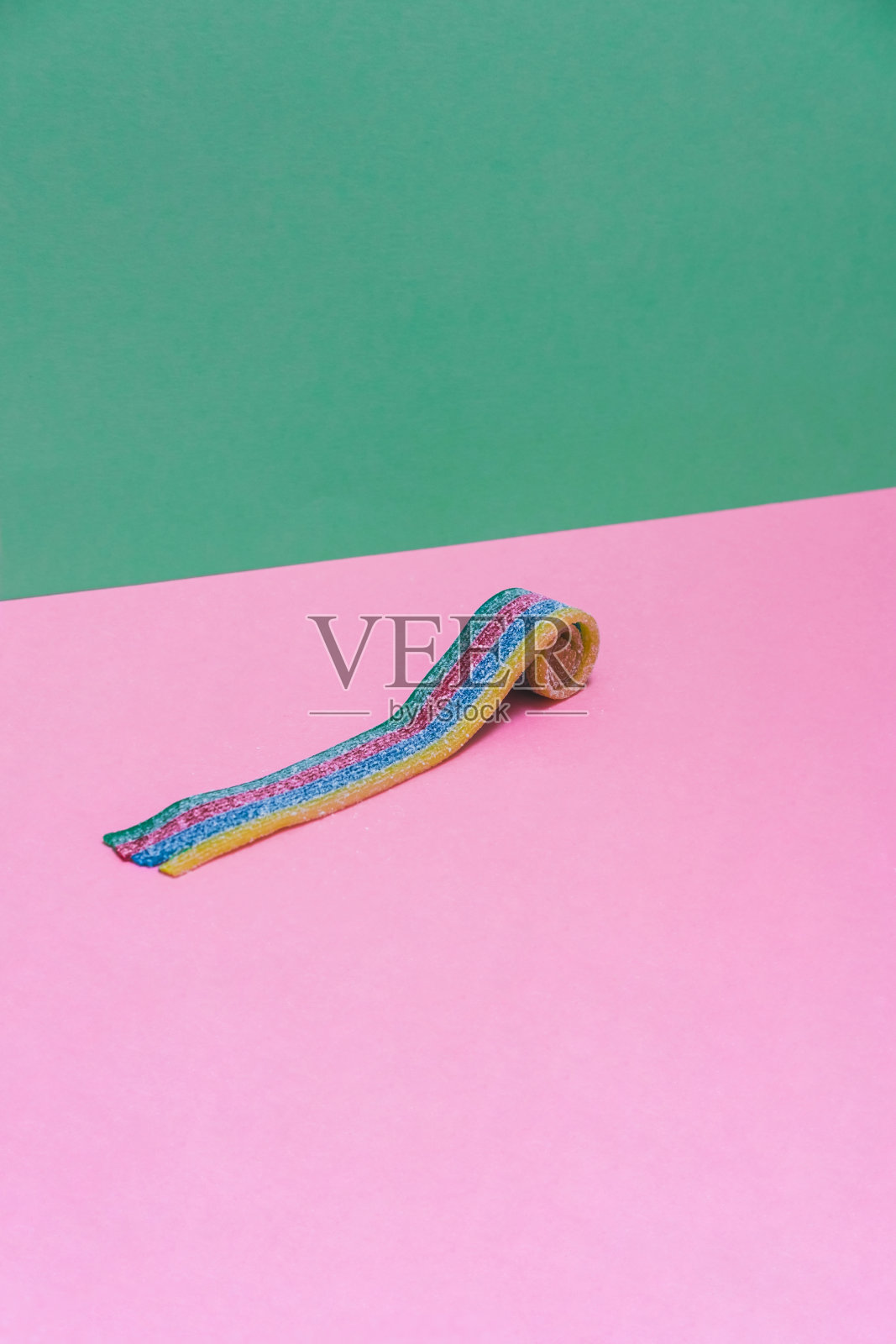 一个粉红和绿色背景的彩虹口香糖。最小的艺术。照片摄影图片