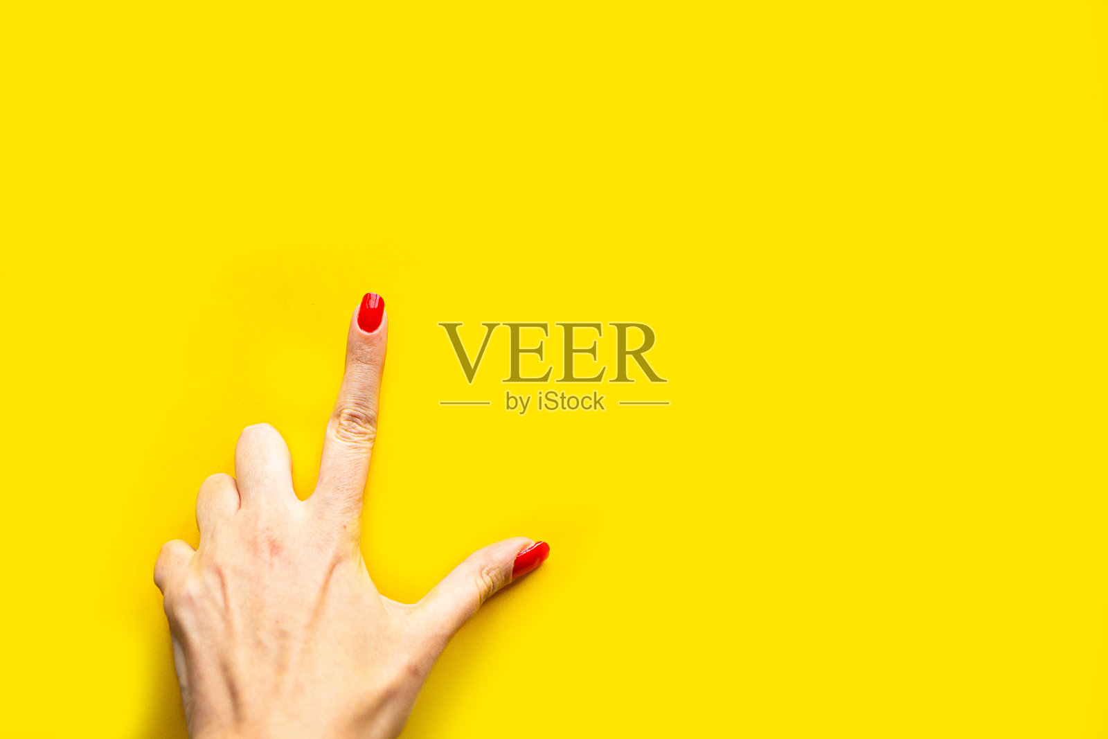 女人的手在亮黄色的背景上做点手势。最小的概念。为文本复制空间照片摄影图片