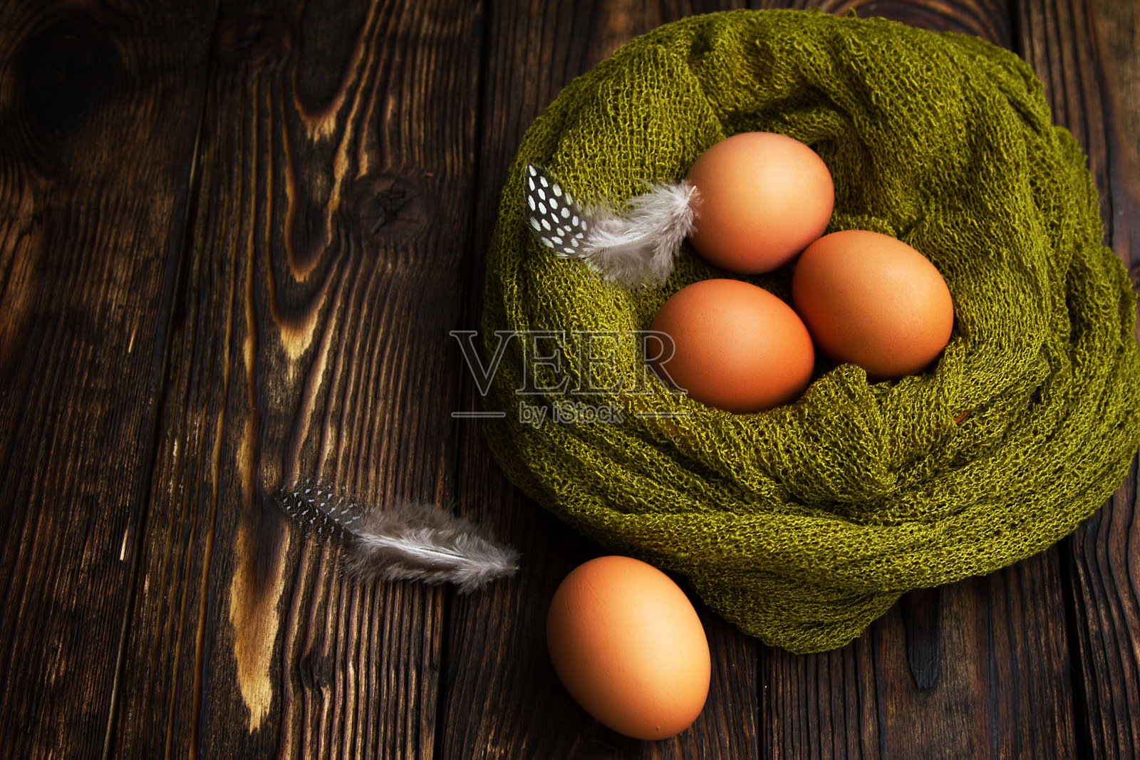 在木制背景上编织的巢里的天然蛋照片摄影图片