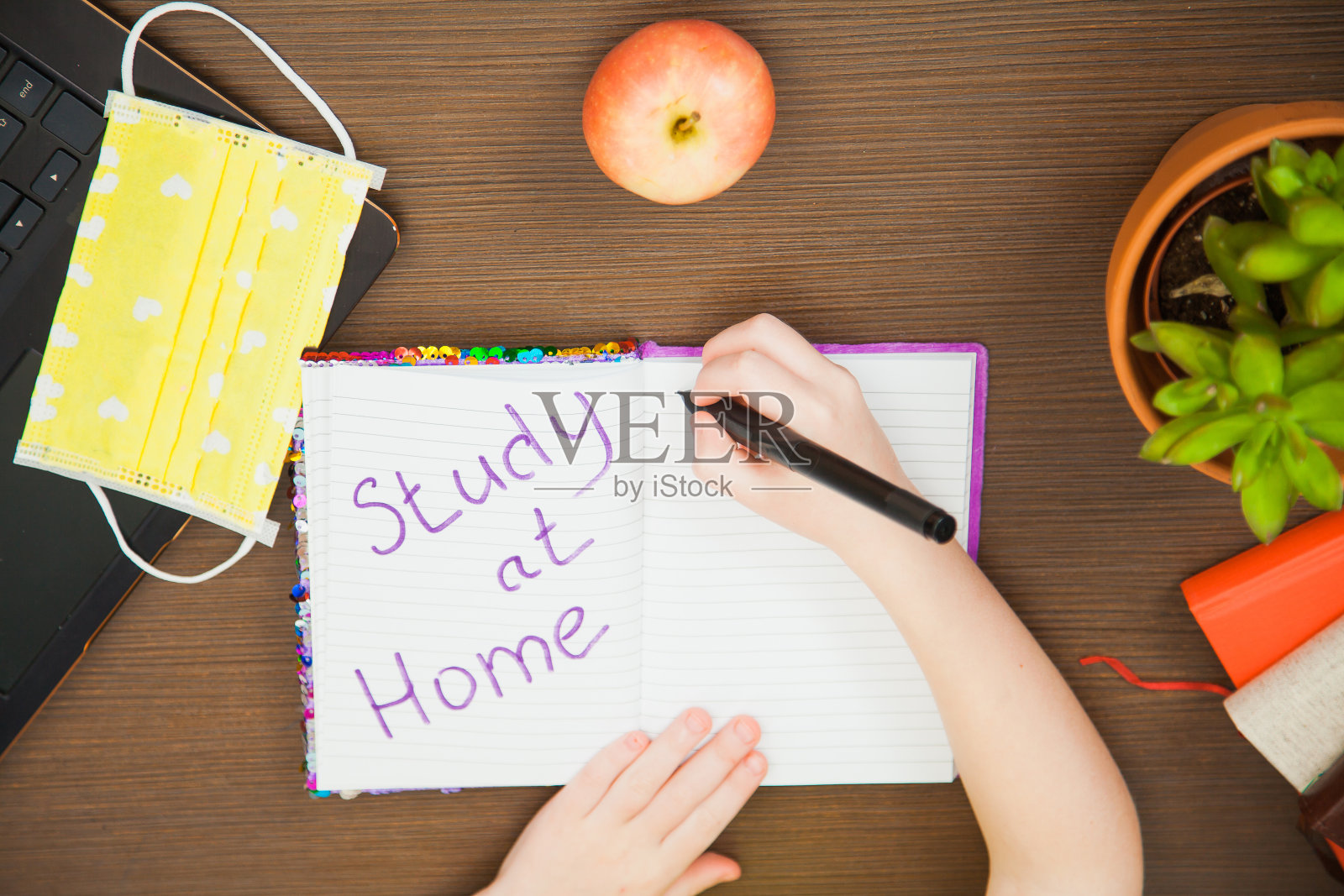 在家平躺影像孩子手拿医用抗病毒口罩写字学习照片摄影图片