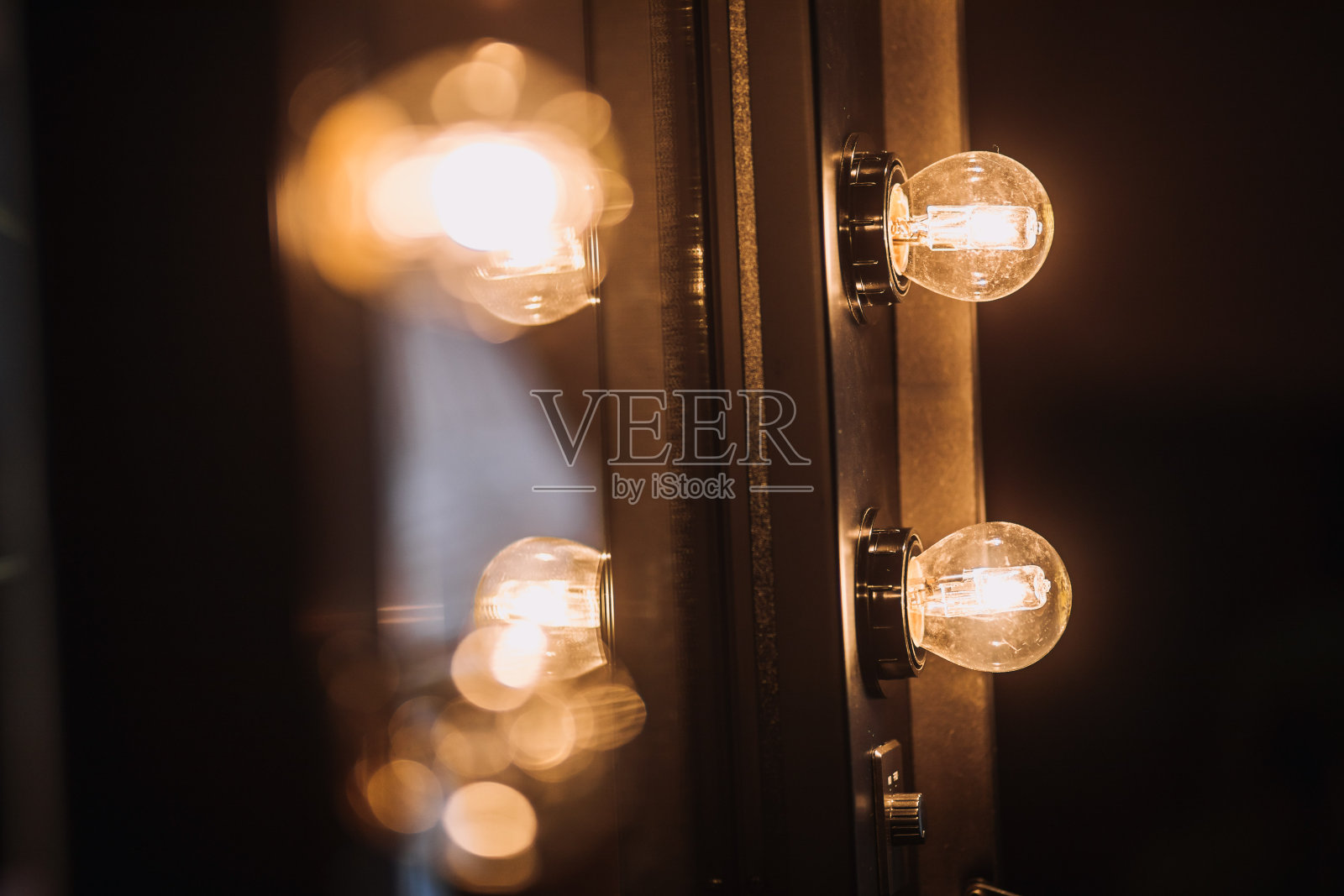 老式灯泡对着镜子在黑暗的背景照片摄影图片