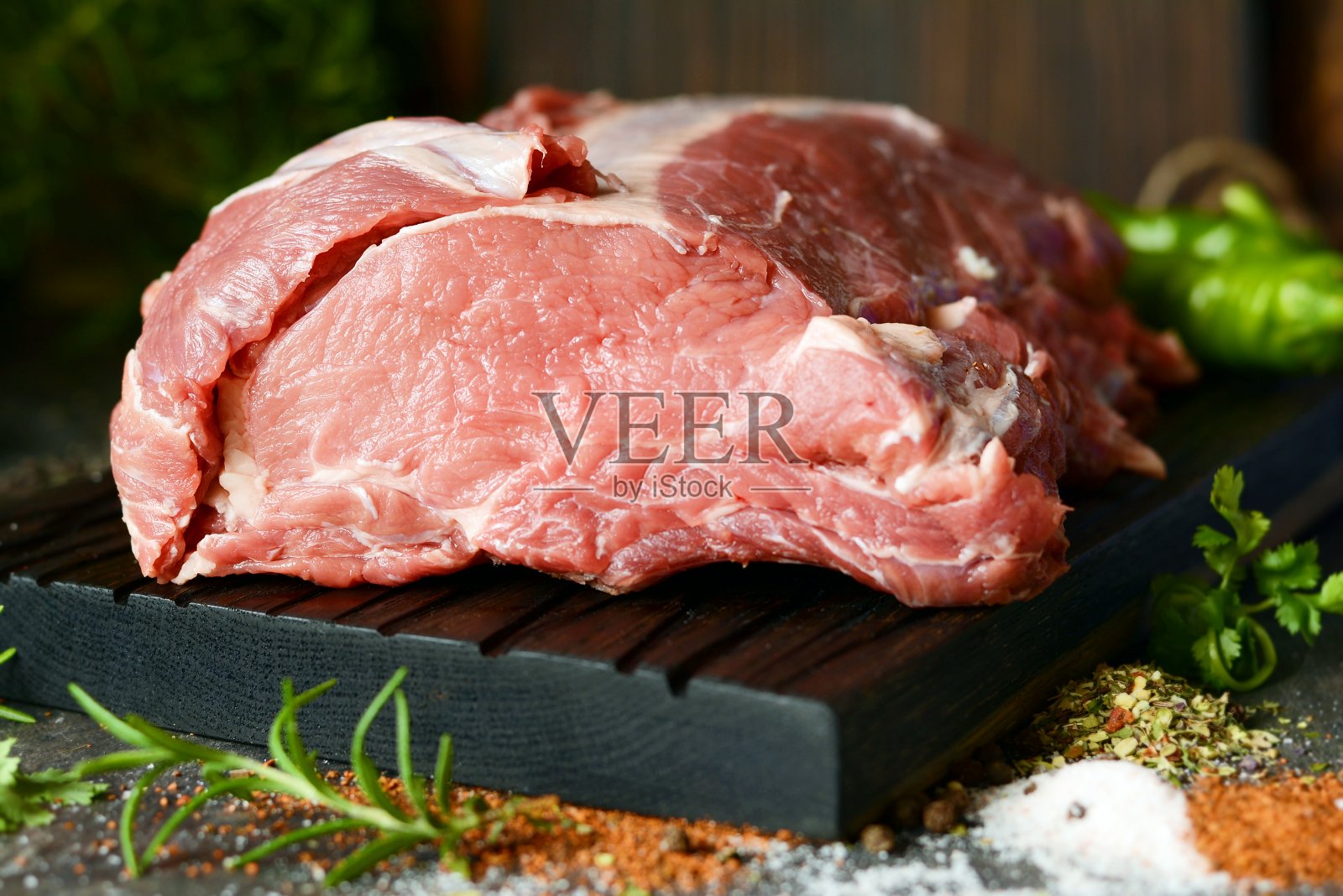 新鲜的生猪腰肉放在木板上，配上香草，香料和海盐。烧烤的肉。烧烤。做饭用的一块好肉。照片摄影图片