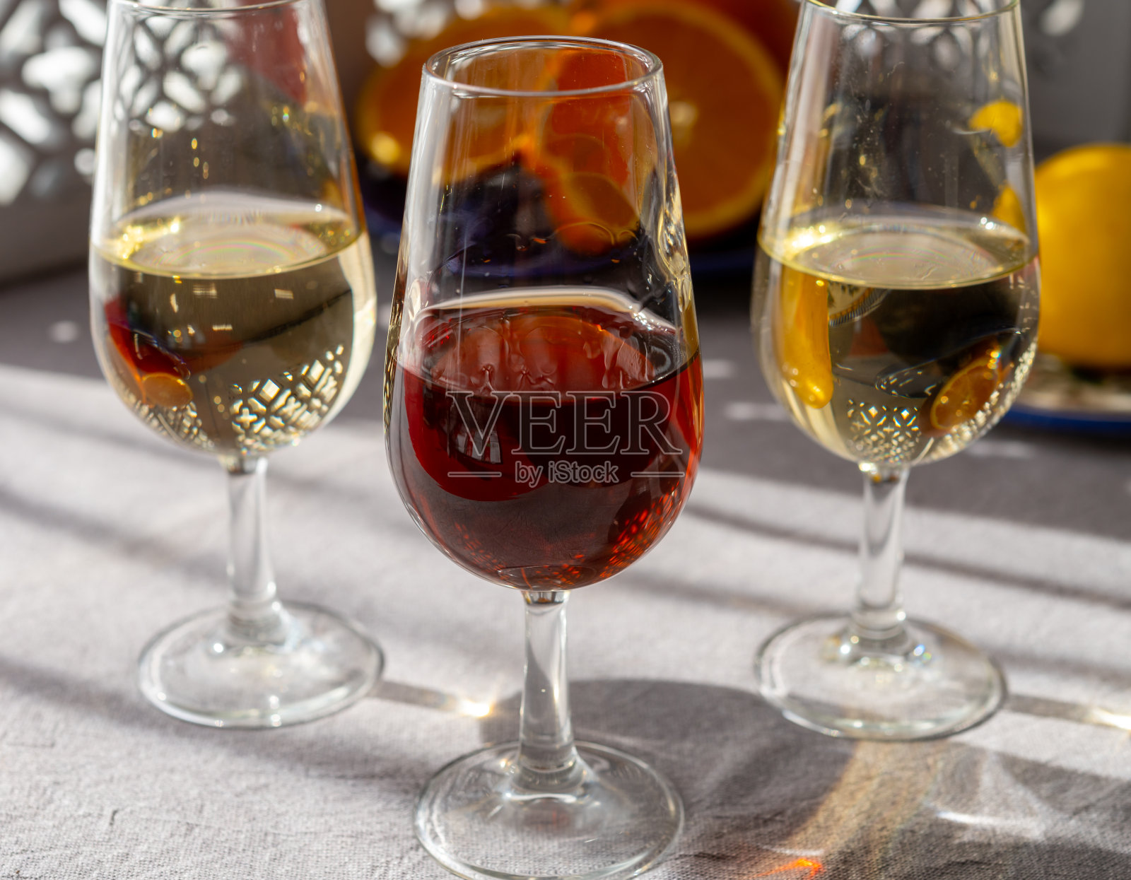 玻璃杯与冷干菲诺和甜奶油雪利强化葡萄酒和橙色阳光，安达卢西亚风格的室内背景照片摄影图片