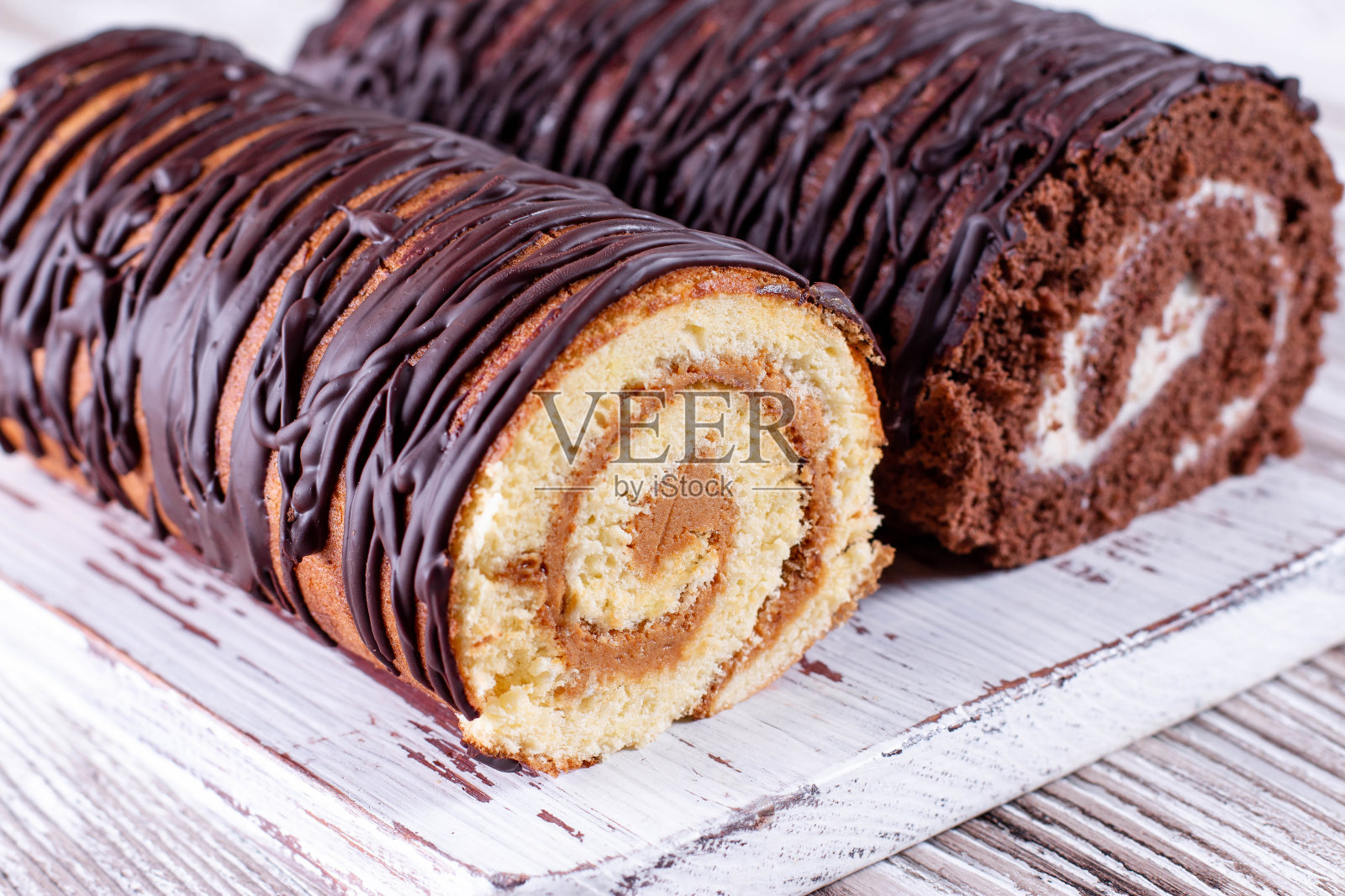 巧克力和白奶油海绵卷。两个面包卷。照片摄影图片