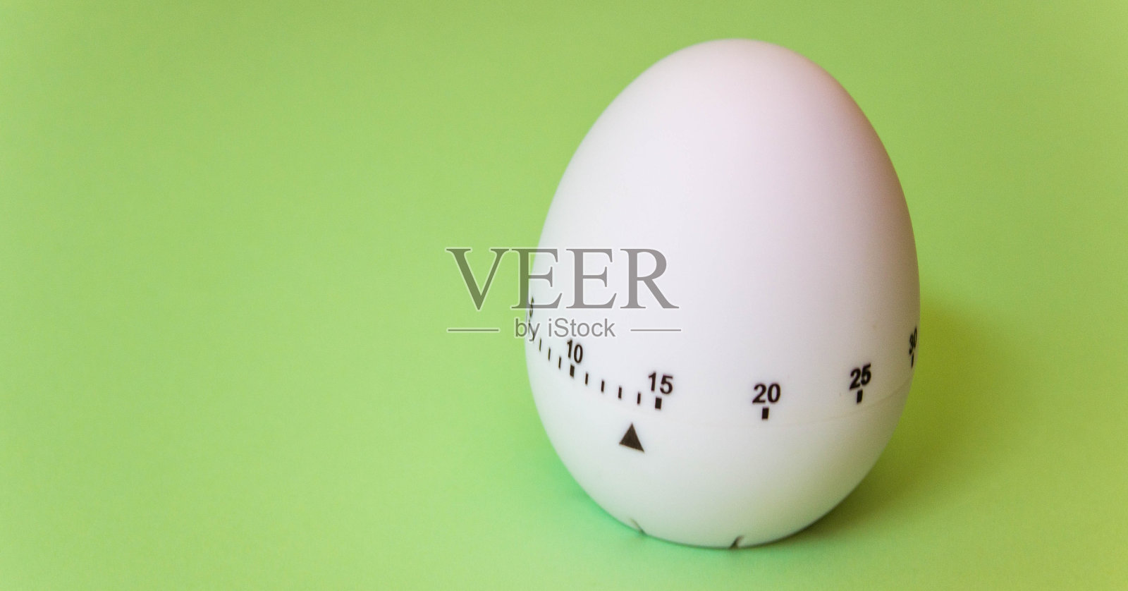 白色鸡蛋计时器在绿色背景。厨房复活节快乐。家庭相关，家庭住宿。免费空间。平躺照片摄影图片