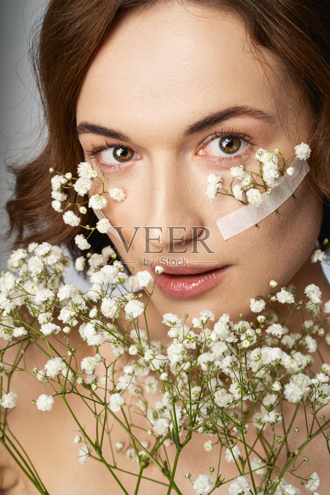 带着小白花的快乐美丽的女人照片摄影图片