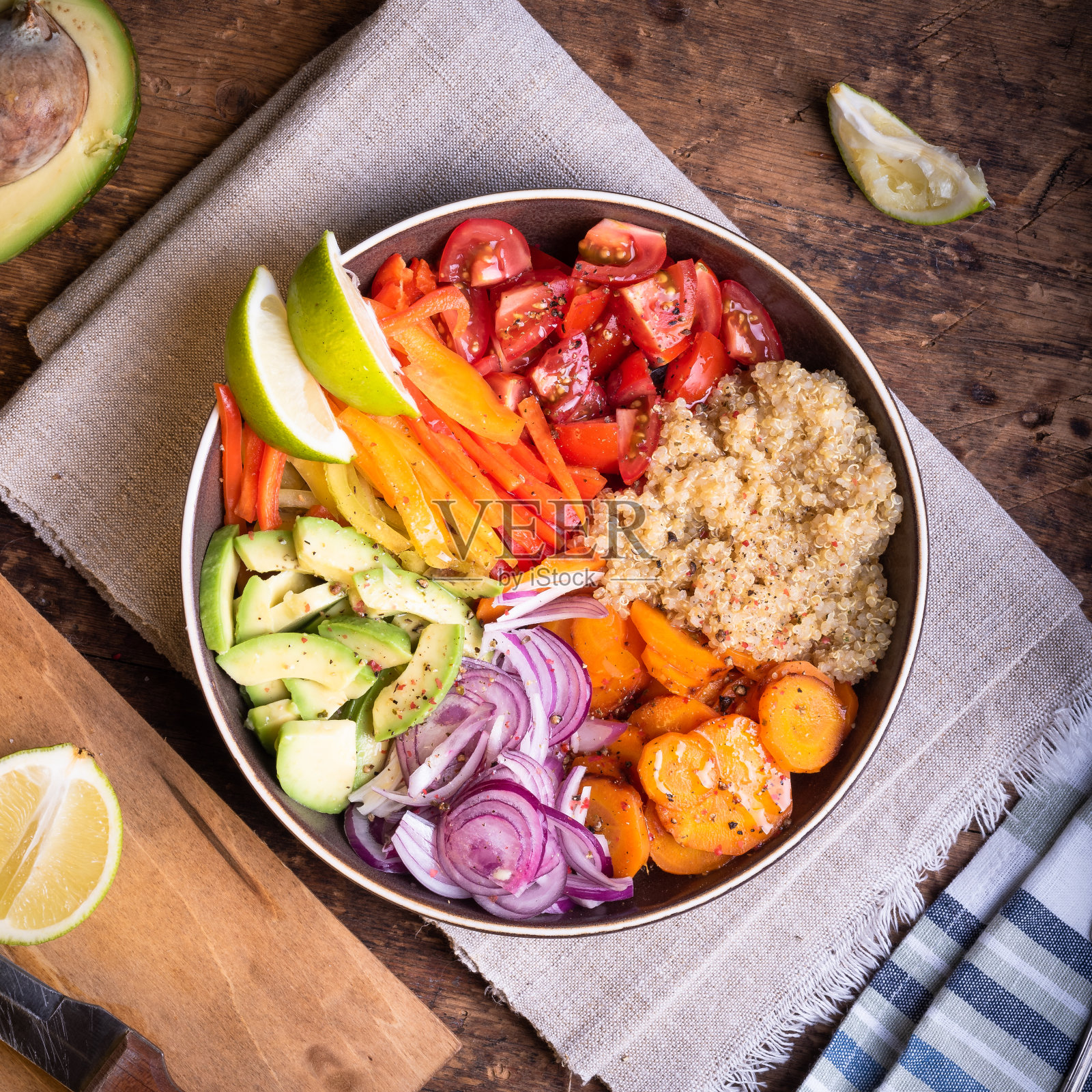 佛碗配素食沙拉，胡萝卜，辣椒，牛油果，洋葱，番茄，藜麦和酸橙片照片摄影图片
