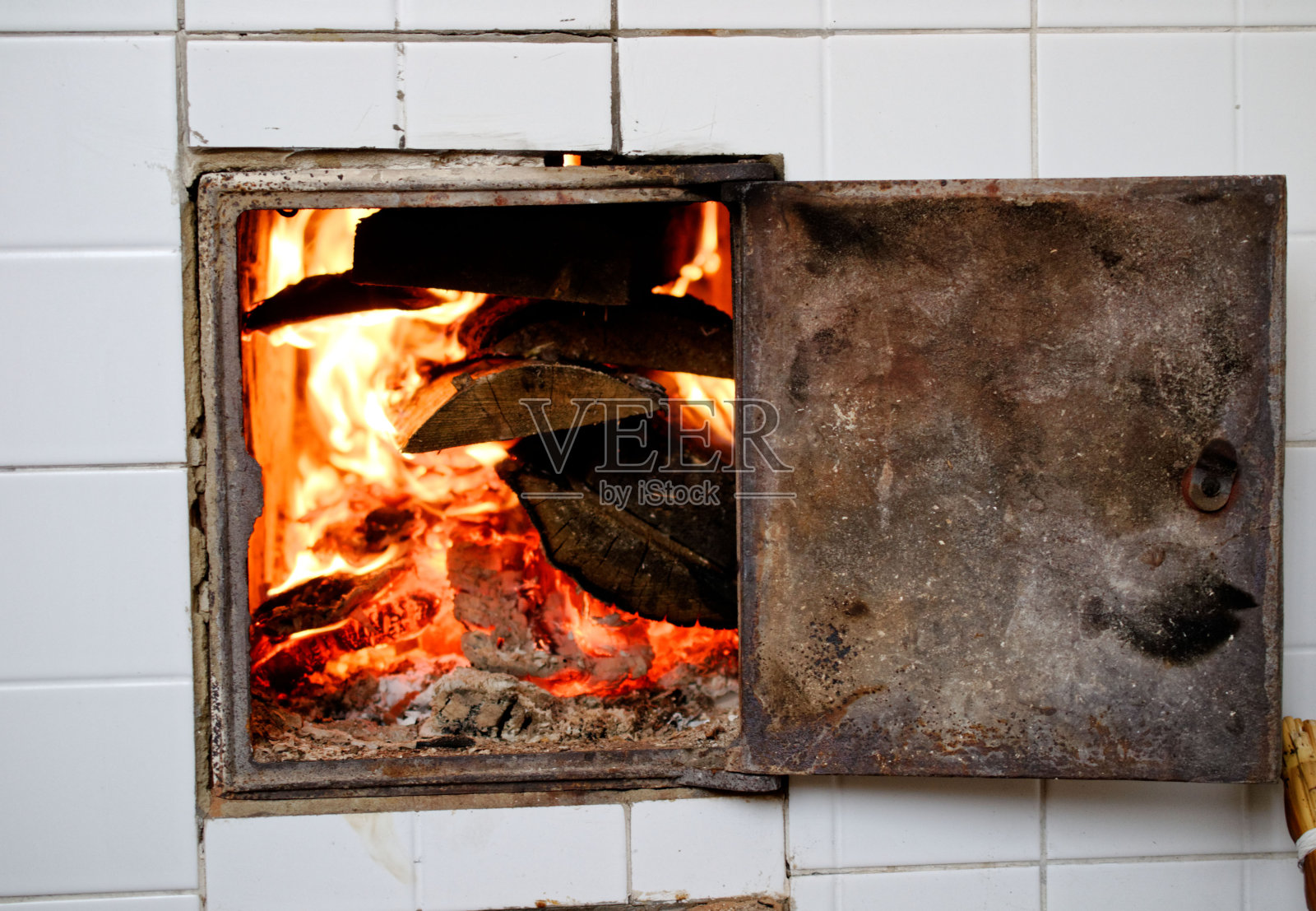 在炉子里烧木柴。照片摄影图片