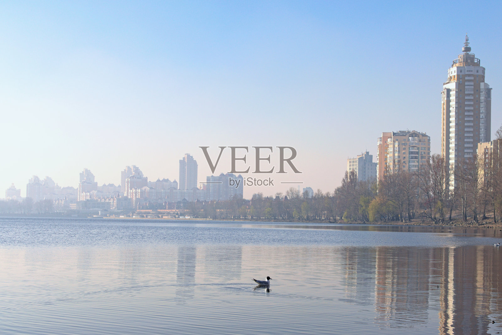 令人惊叹的阳光明媚的早晨景观德聂伯河附近的奥伯隆区。在清晨的雾霾中，堤岸上是摩天大楼。建筑物倒映在水中。基辅,乌克兰照片摄影图片