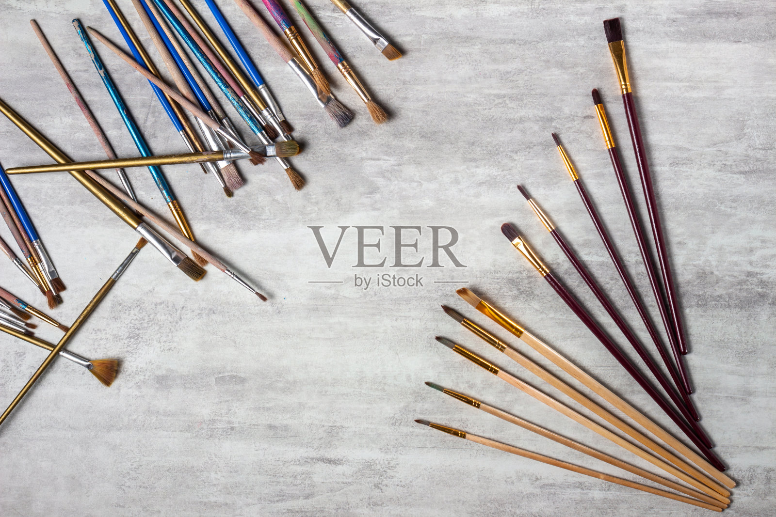 画笔分散在桌子上的灰色背景，绘图工具俯视图，复制空间，特写照片摄影图片