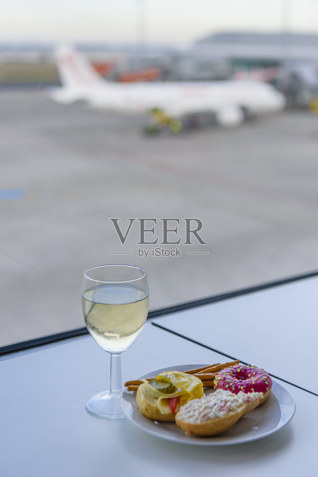 在机场的商务休息室，一杯葡萄酒和一些食物照片摄影图片