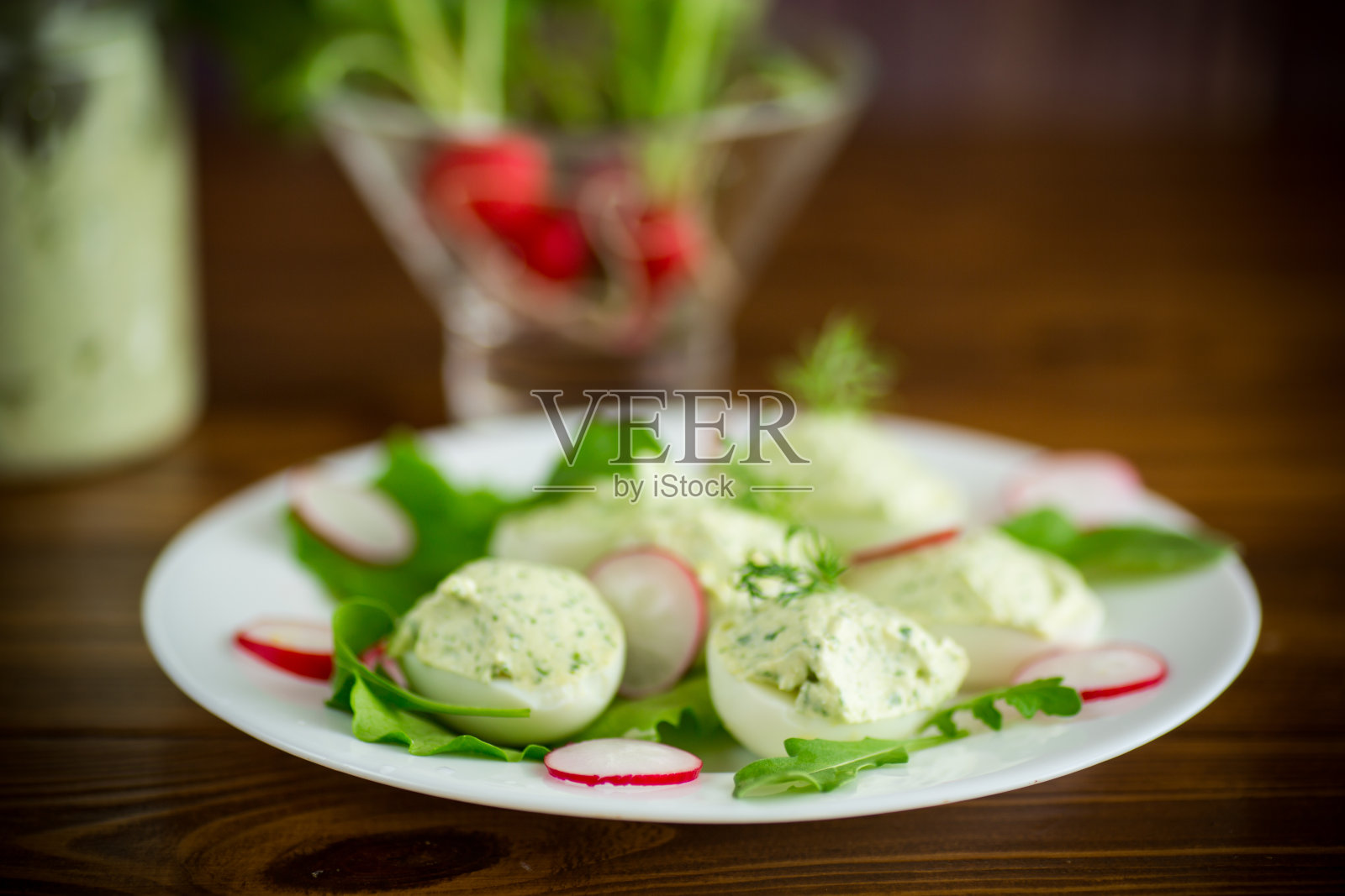 煮熟的荷包蛋配上绿色的芝士，馅料是芝麻菜叶和萝卜照片摄影图片