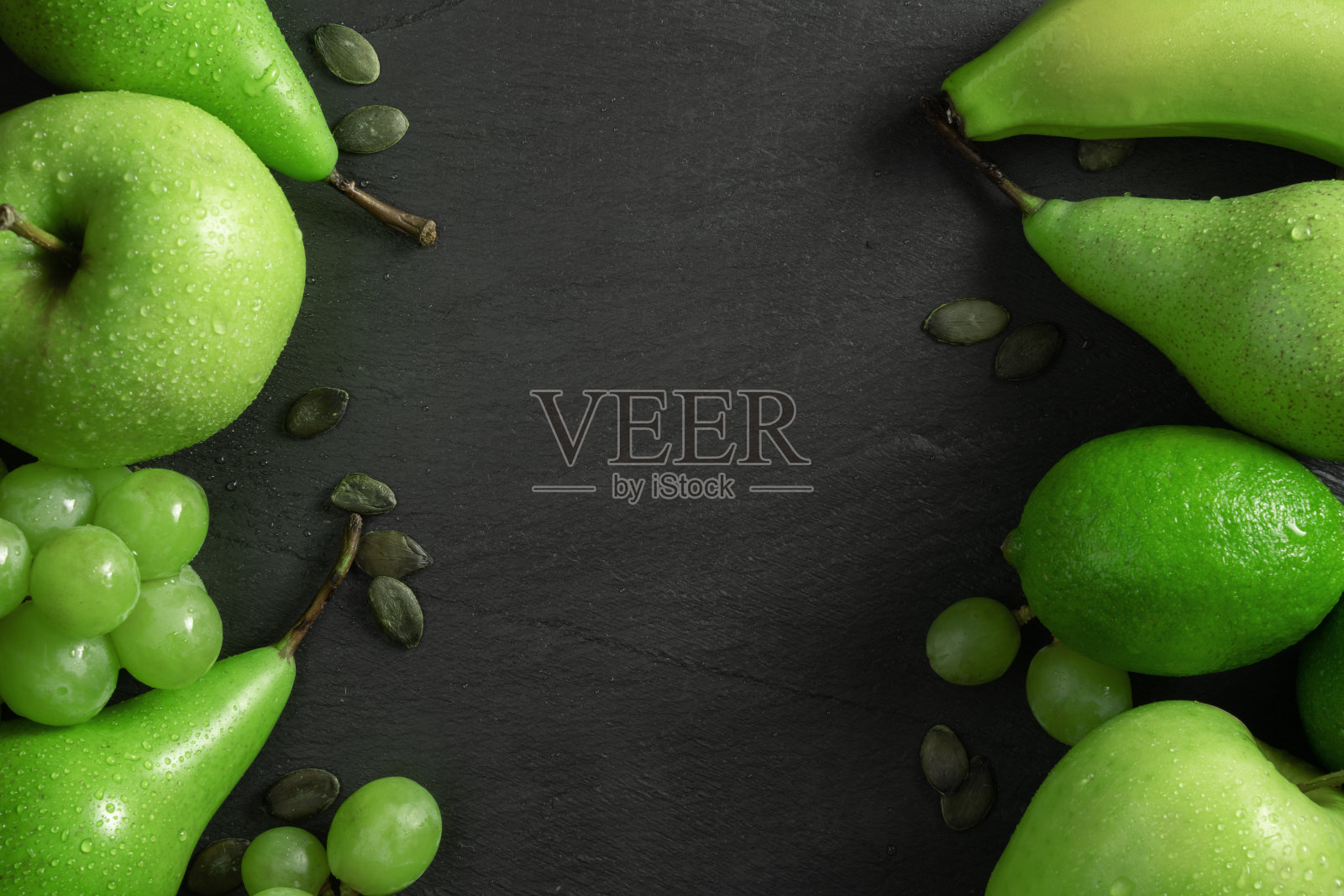 夏季抽象创意时尚新鲜概念。绿色的水果背景，深色的石纹板与复制空间。平放俯视图照片摄影图片