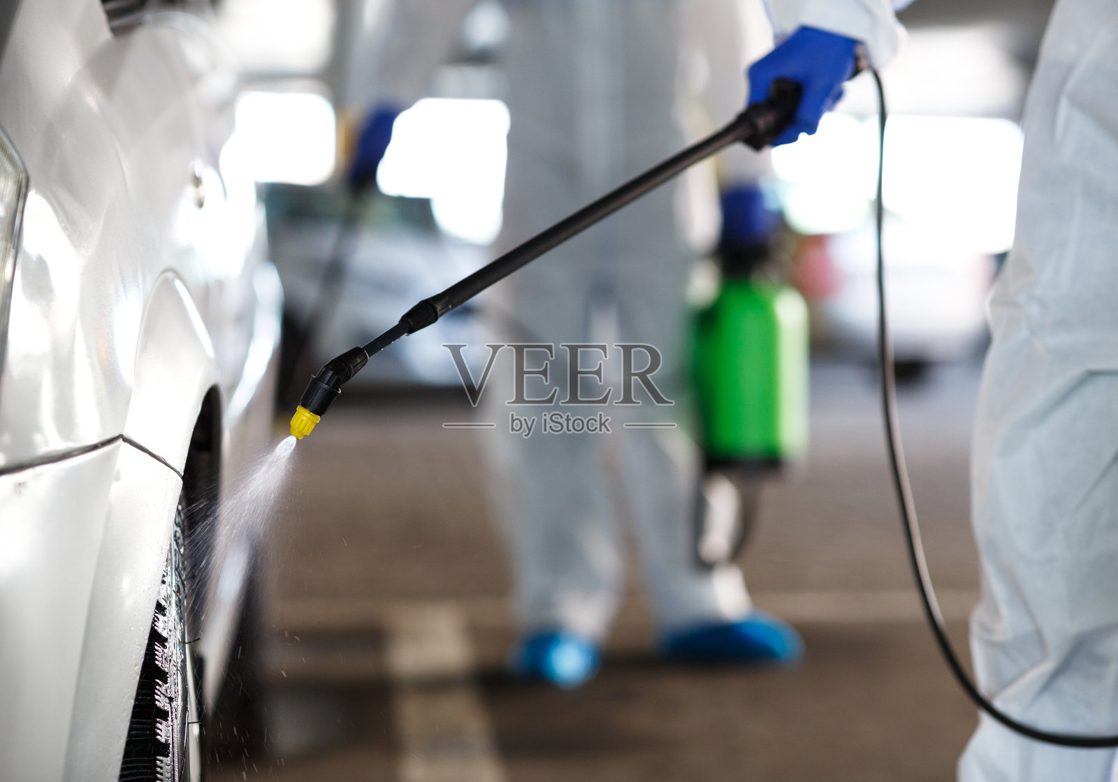 无法辨认的工人用化学品洗车，新冠肺炎照片摄影图片