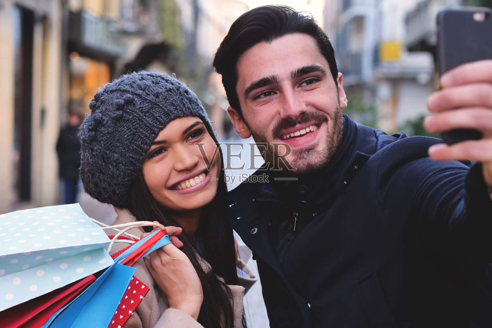 一对年轻的订婚夫妇或朋友，当他们一起购物，一起玩乐照片摄影图片