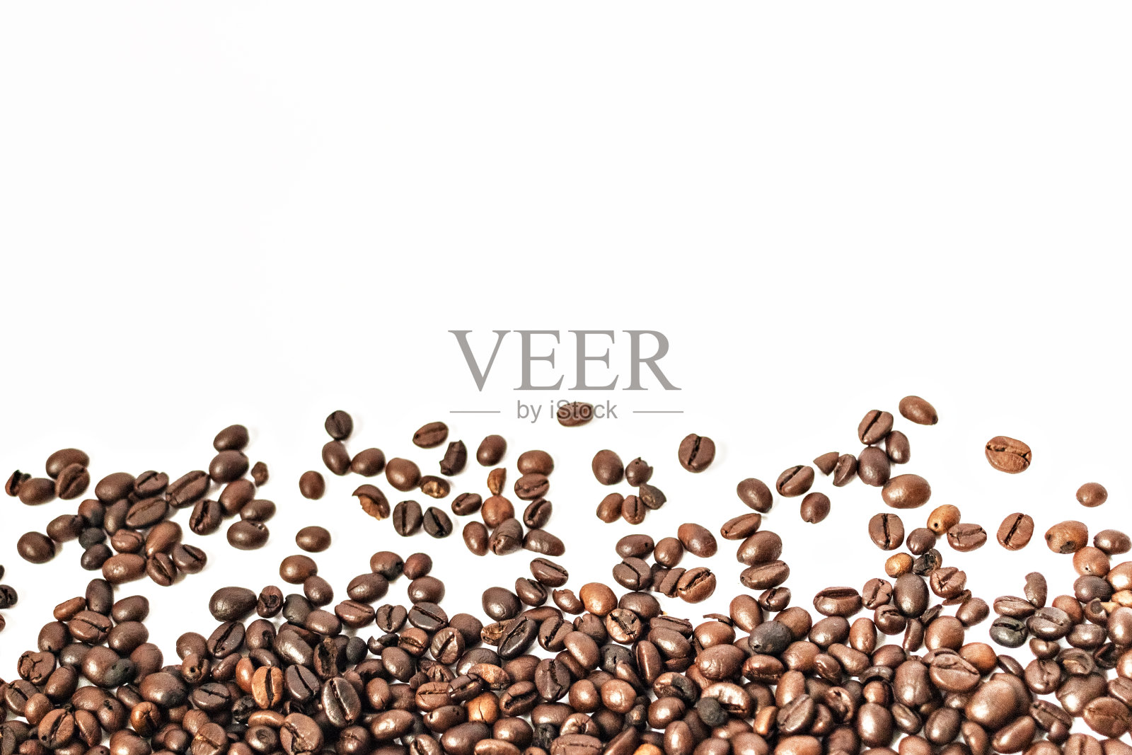 在白色的背景下，闪亮的新烤咖啡豆。孤立。照片摄影图片