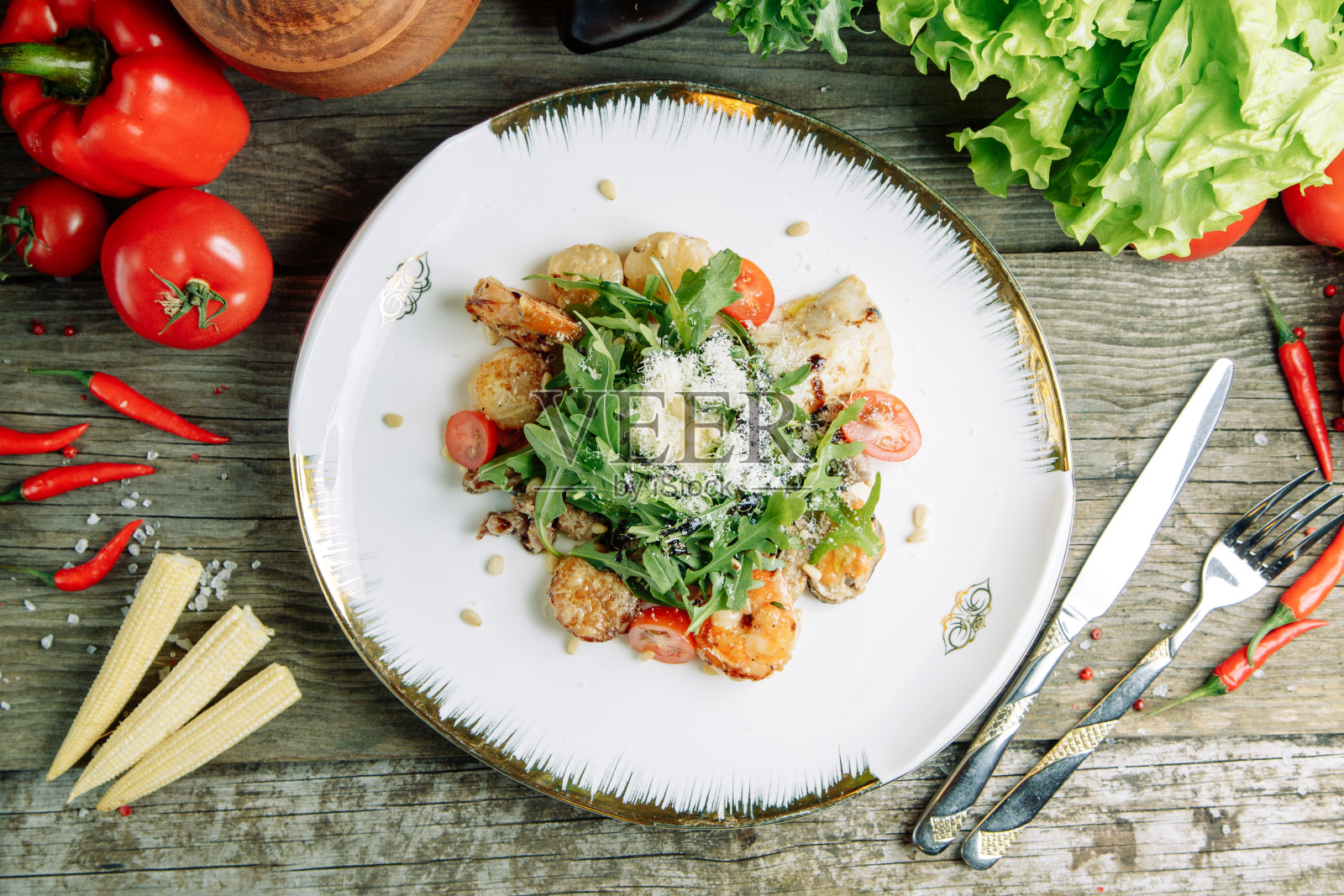 有虾、鳄梨和芝麻菜的沙拉。餐厅菜肴在木背景与蔬菜。照片摄影图片