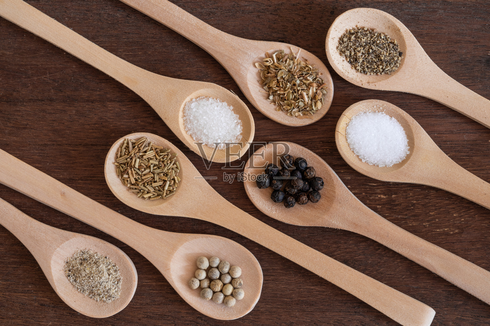 各种香料在木桌的木勺背景，糖，胡椒，盐，姜黄，迷迭香，牛至，拷贝空间照片摄影图片