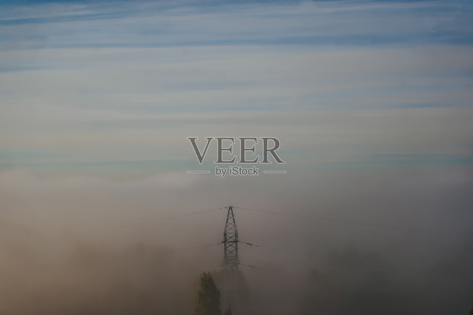 电力传输高压塔在雾天背景下照片摄影图片