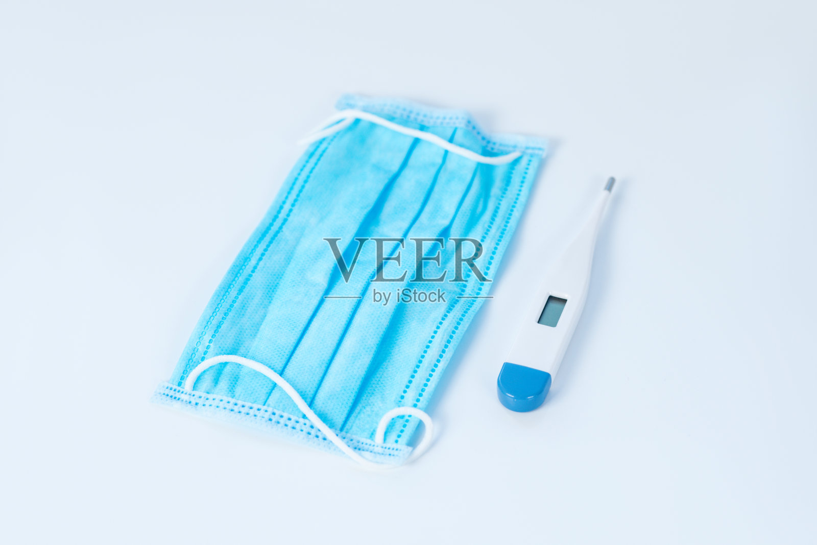 防护面罩和数字温度计放在桌上照片摄影图片