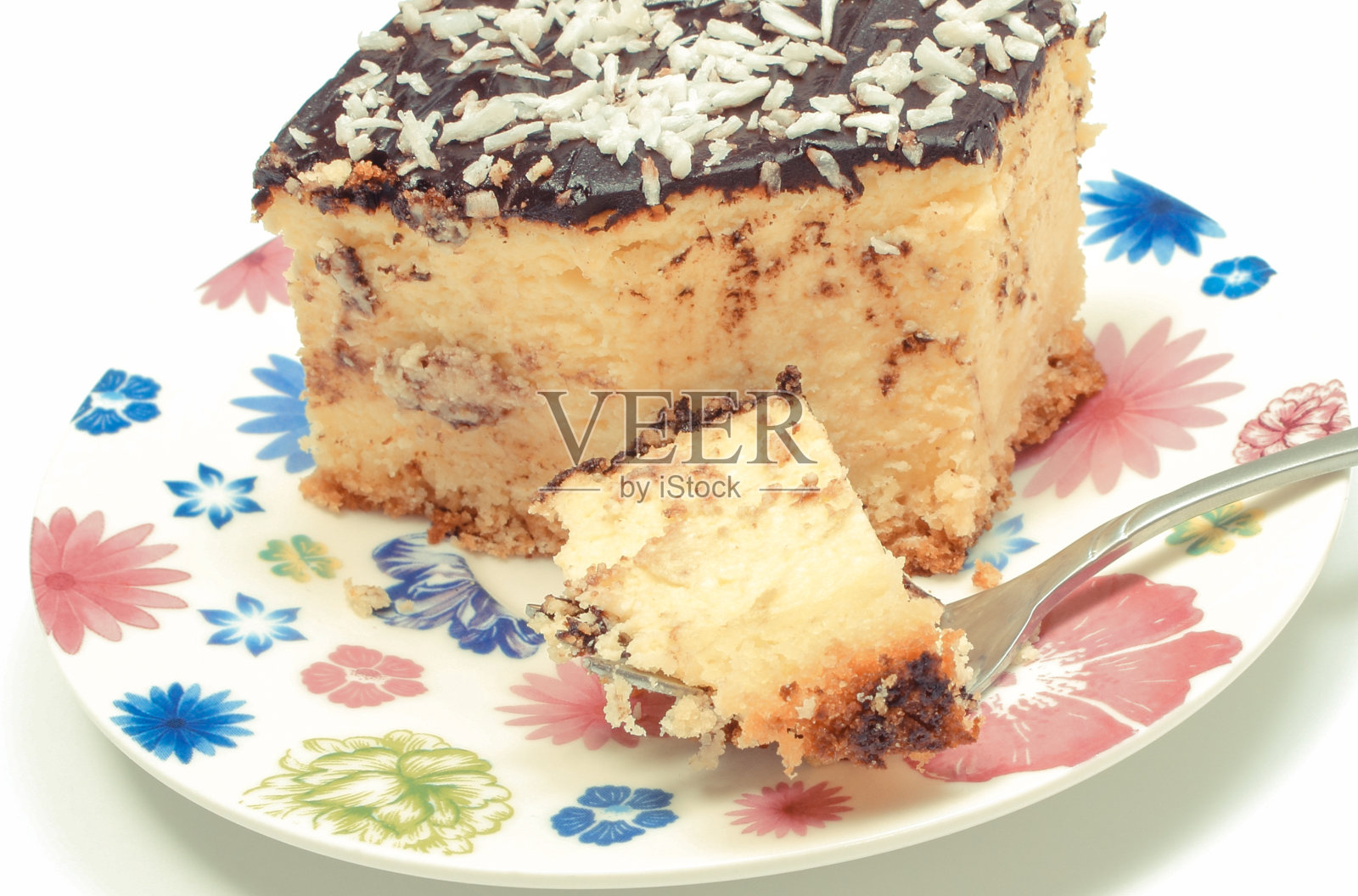 新鲜烤芝士蛋糕，银色叉，五颜六色的盘子。白色背景照片摄影图片