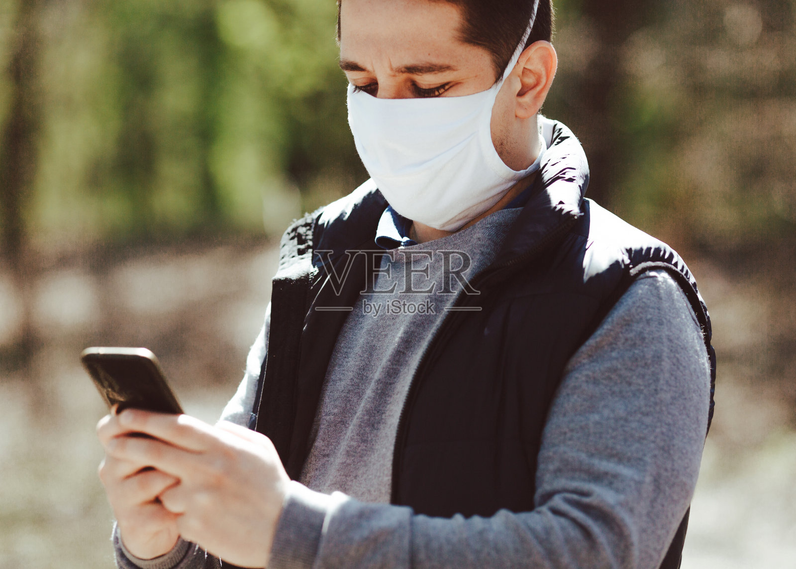 用手机抗病毒的人。照片摄影图片