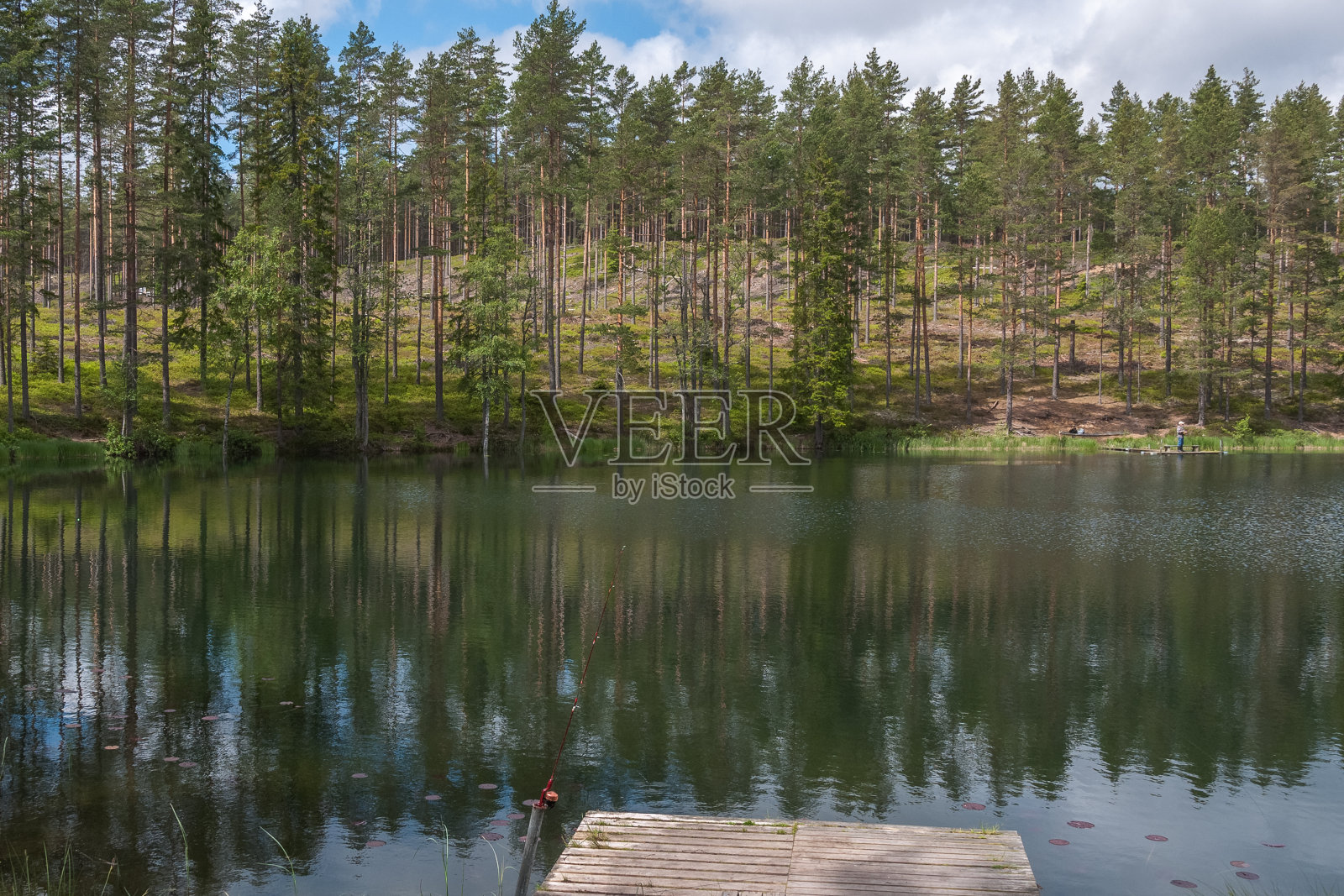 鱼竿旋转，有线的特写镜头。鱼竿在码头上的鱼竿支架上。瑞典。有选择性的重点。长时间曝光照片摄影图片
