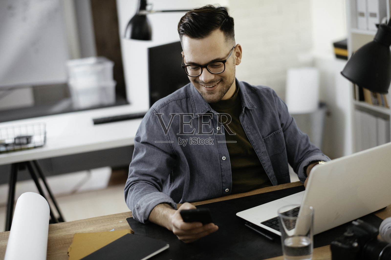 年轻英俊的商人在办公室工作。照片摄影图片