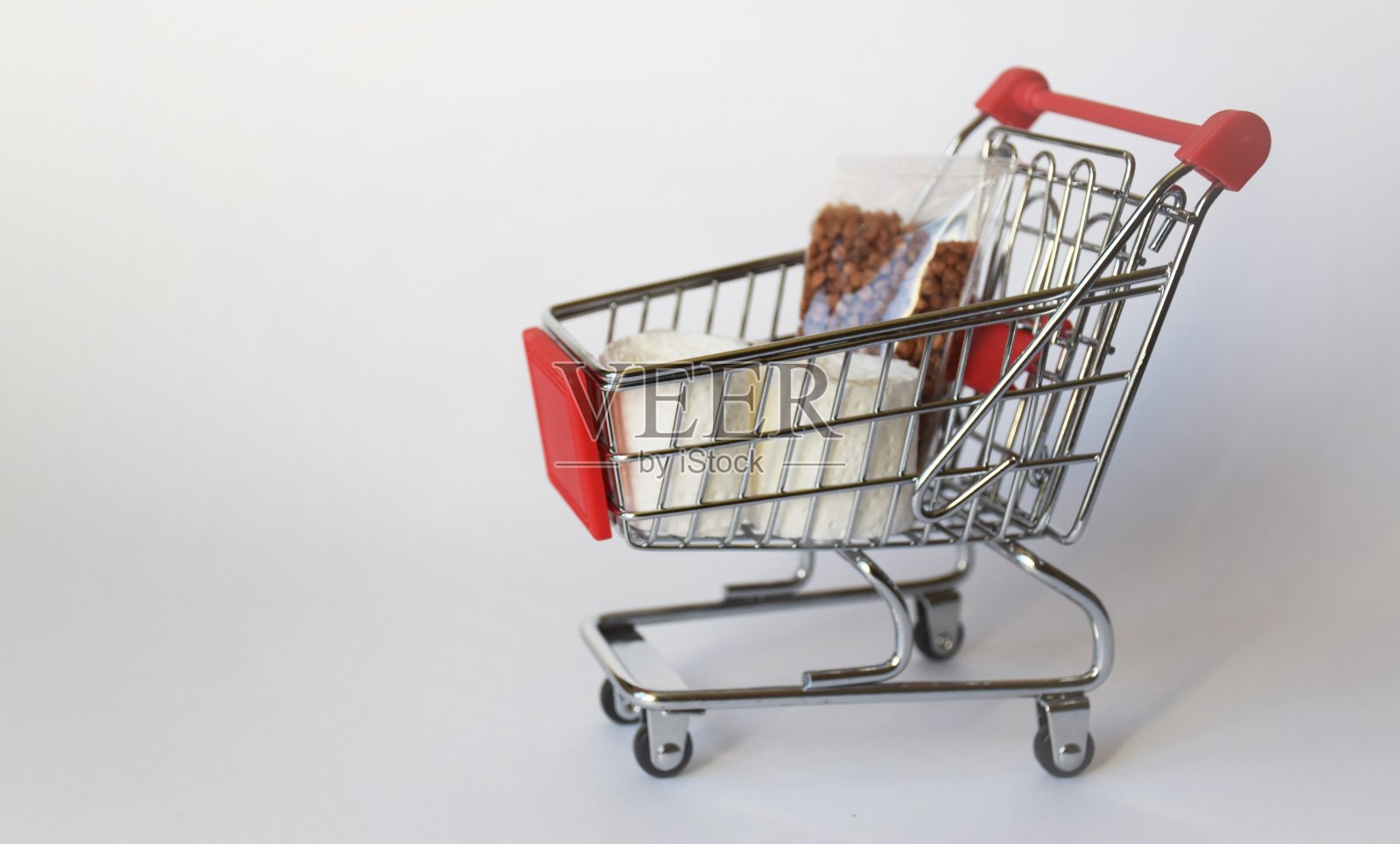 购物车，白色背景上的一包荞麦，在大流行期间购买产品的概念，冠状病毒感染照片摄影图片