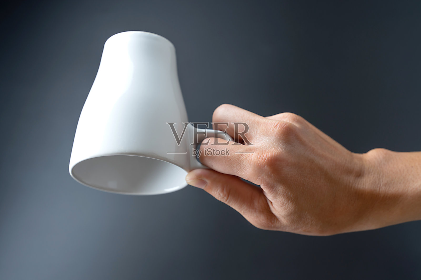 手握杯子在黑色的背景照片摄影图片