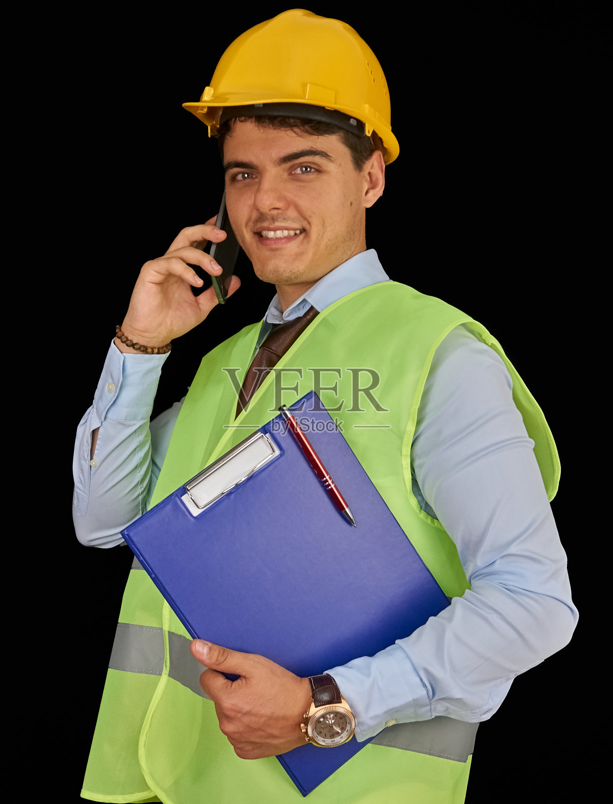 戴着头盔带着剪贴板的年轻工程师正在打电话照片摄影图片