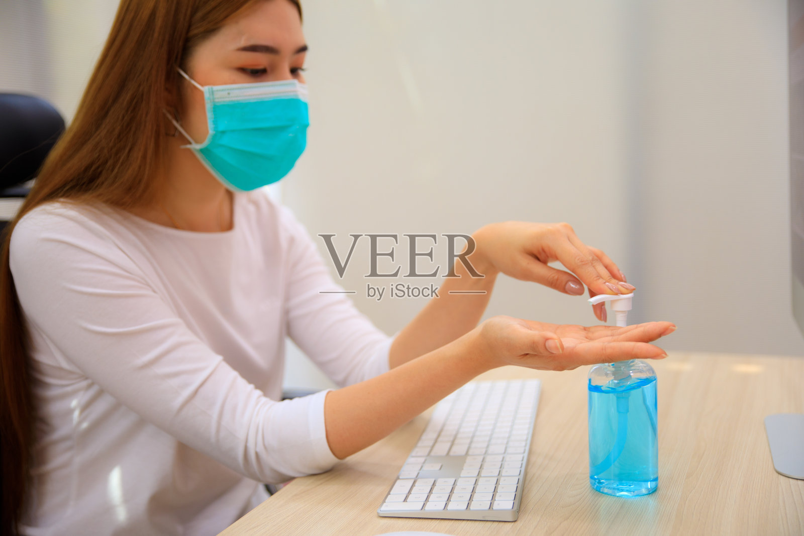 亚洲年轻女性在工作前经常使用洗手液洗手，以预防冠状病毒感染。Covid-19社会距离。照片摄影图片