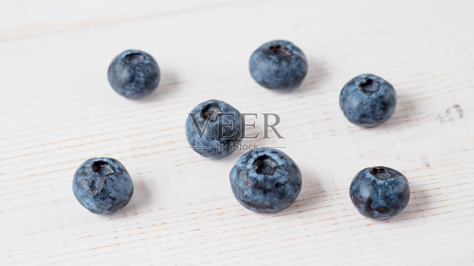 木质背景上的新鲜蓝莓。照片摄影图片