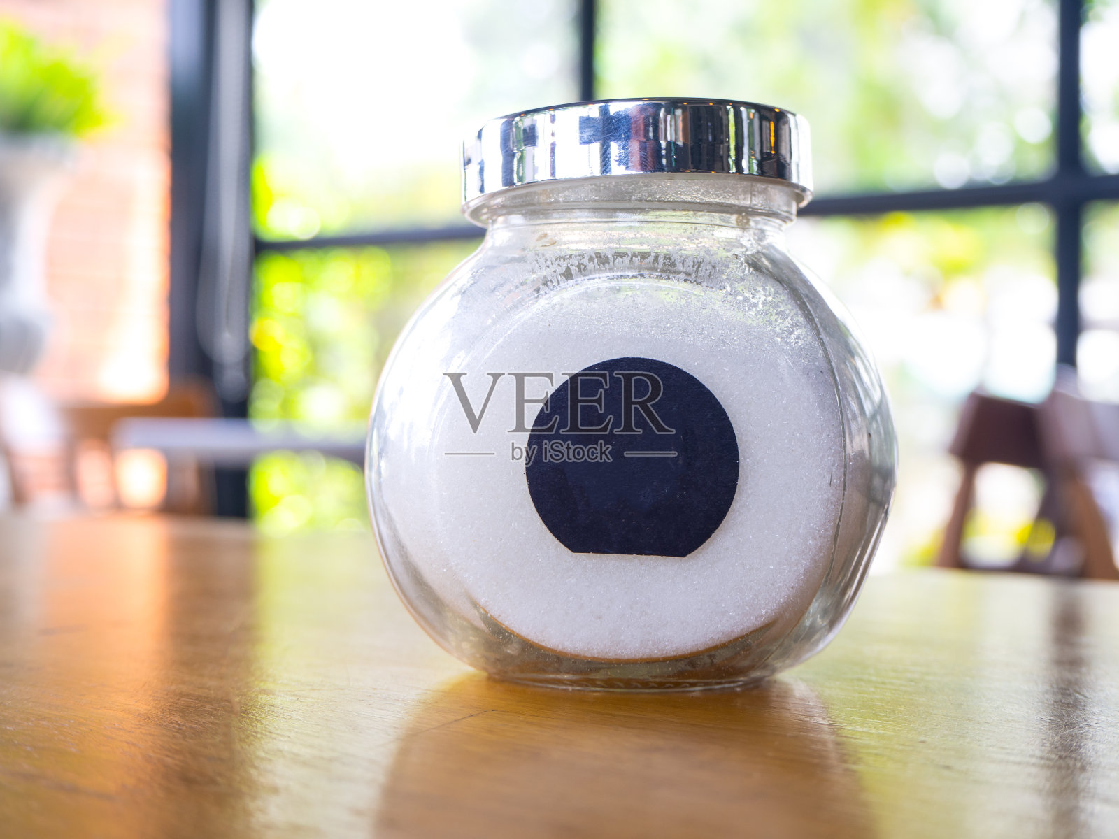 咖啡用的木桌上的玻璃罐里的糖。照片摄影图片