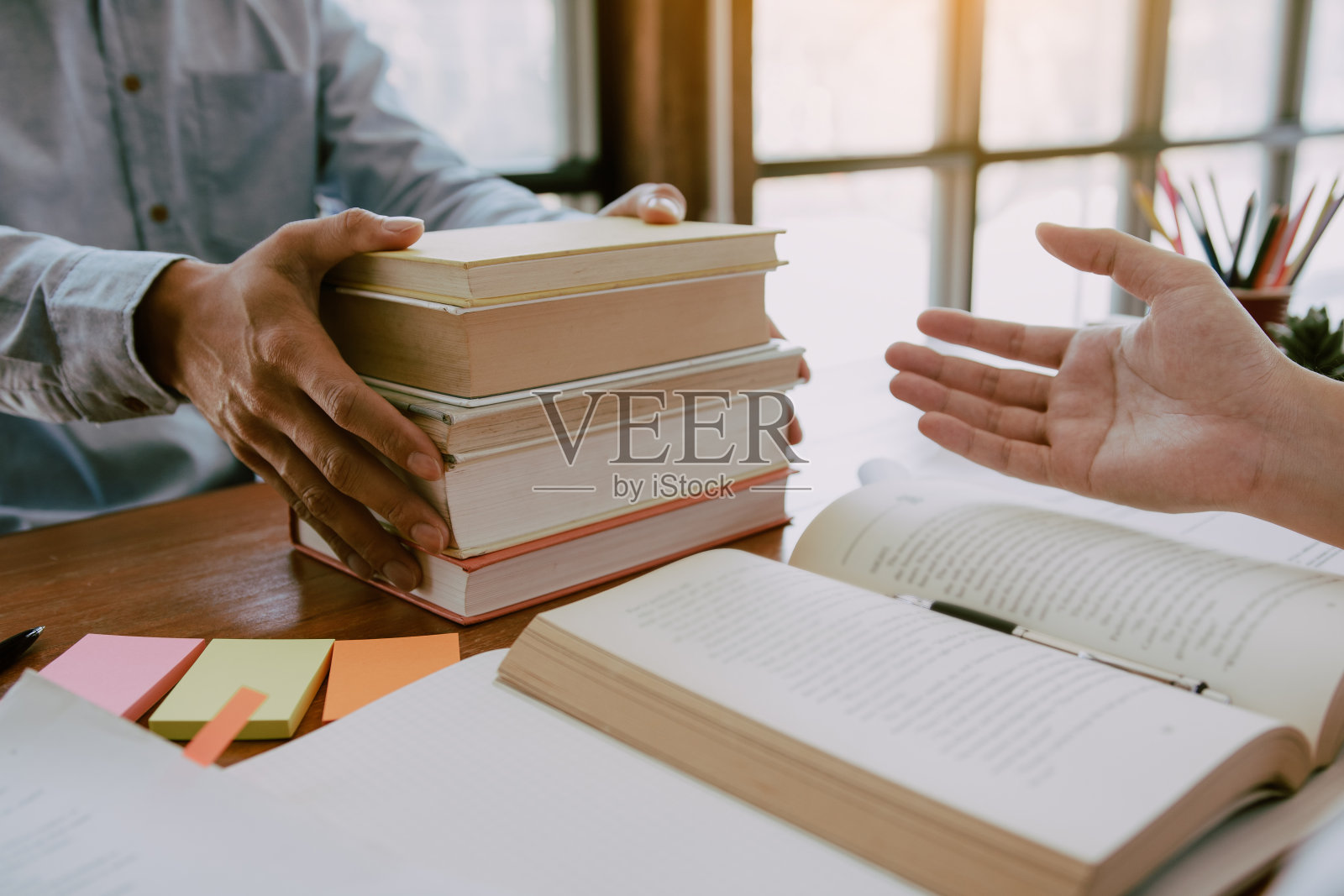 一个十几岁的学生在他的房间里做家庭作业，在笔记本上写东西。照片摄影图片